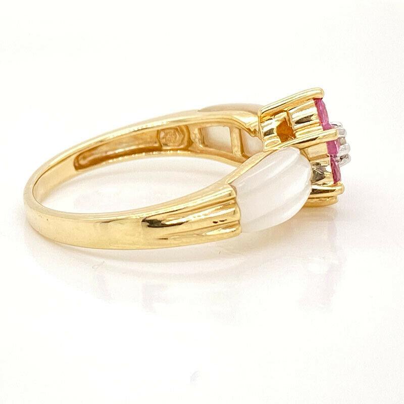 Excellent condition. This solid 14K yellow gold ring features a natural diamond in the center, surrounded by 6 natural pink sapphires creating the shape of a flower. On either side of the flower is a piece of mother of pearl. The flower measures