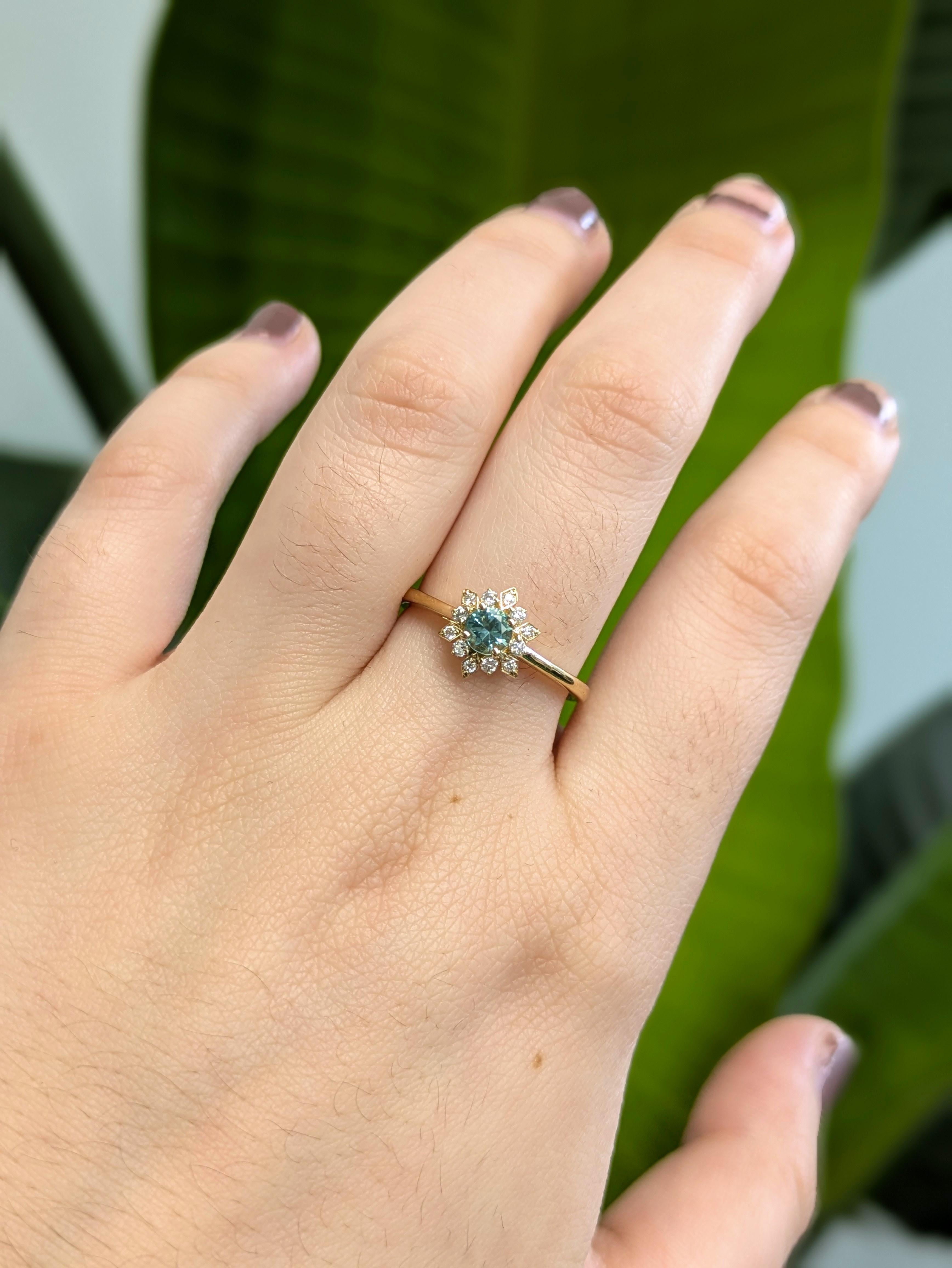 Cette jolie bague capture la douce beauté d'une fleur en éclosion. En son cœur se trouve une rare tourmaline Paraiba de 0,26 carat, connue pour sa couleur bleu-vert lumineuse et rafraîchissante. Entouré de diamants naturels et fabriqué en or jaune
