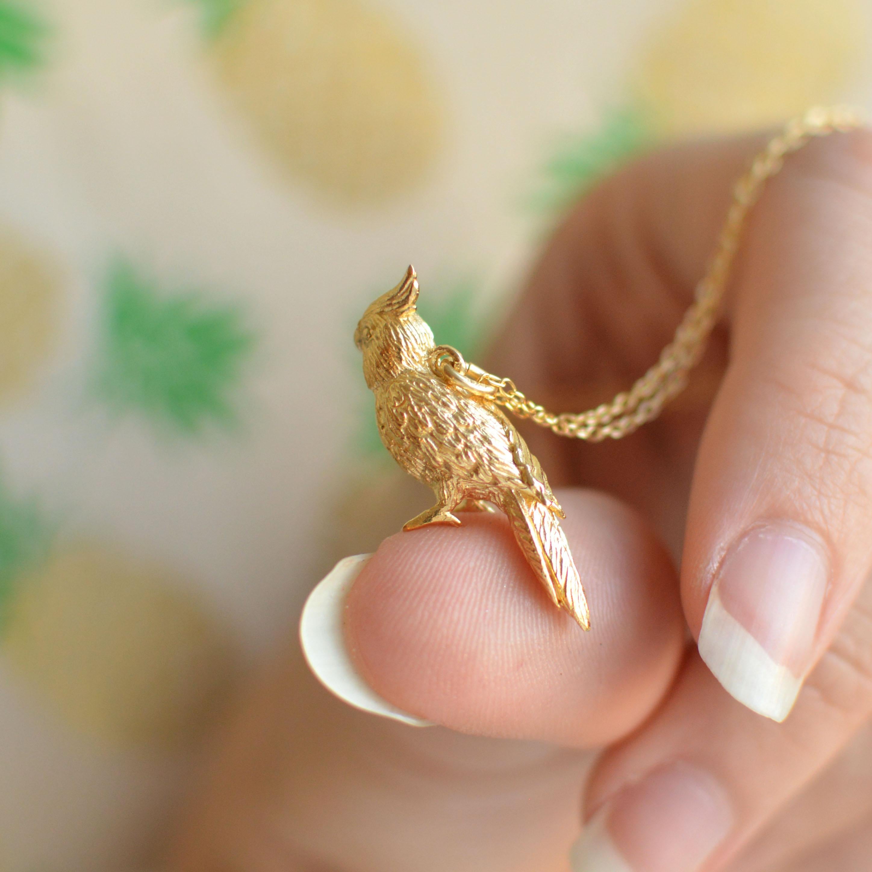 This slender little cockatiel pendant is cast in solid 18 Carat gold and finished by hand, and is created from Lucy's original hand-sculpted design. 

This lovely cockatiel pendant is made in London, United Kingdom using recycled or fairtrade Gold.