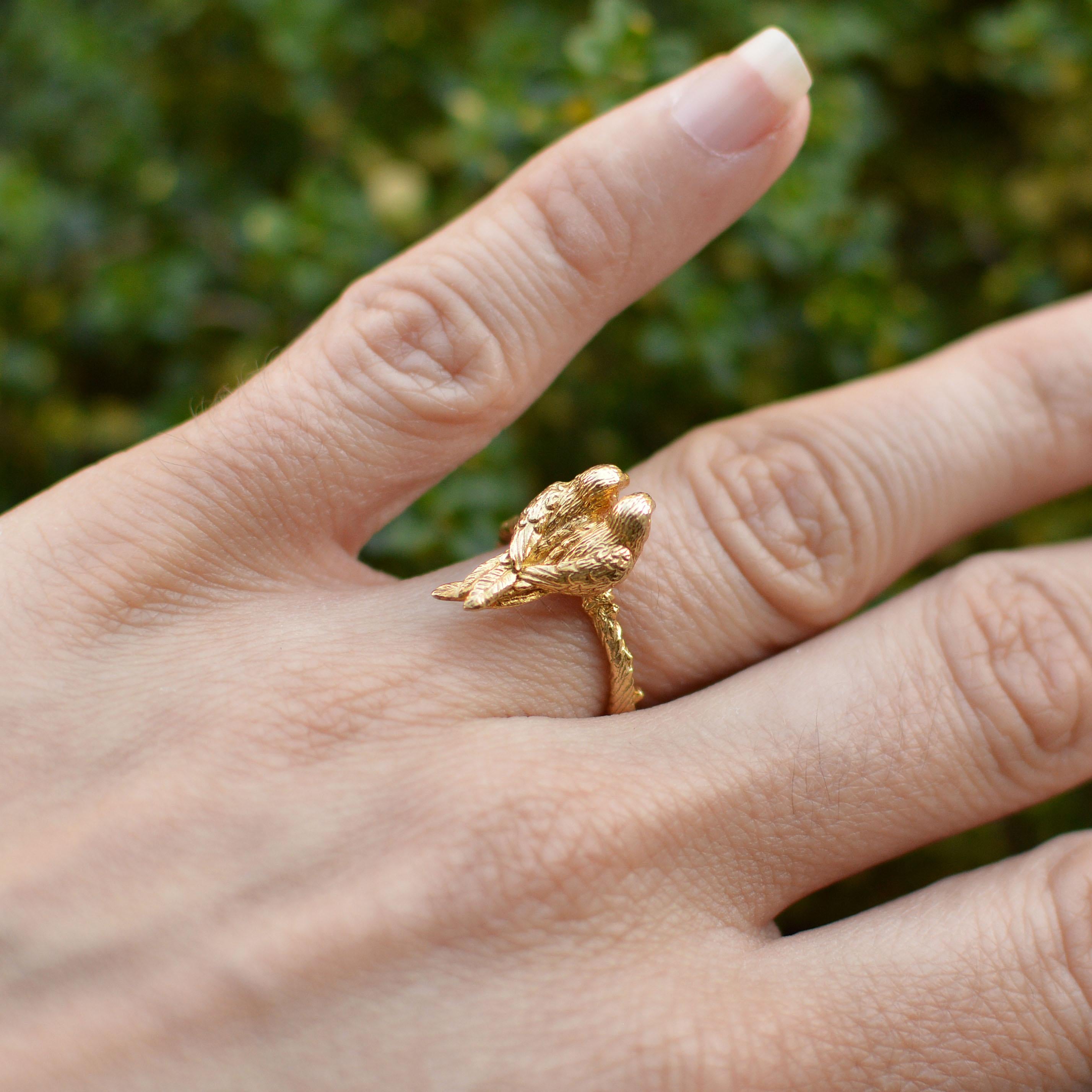 This is a delicate little ring with a branch textured band and two cuddling conure parrots perched on top. This ring is cast in solid 18 Carat gold and finished by hand, and created from Lucy's original hand-sculpted design. 

This piece is made in