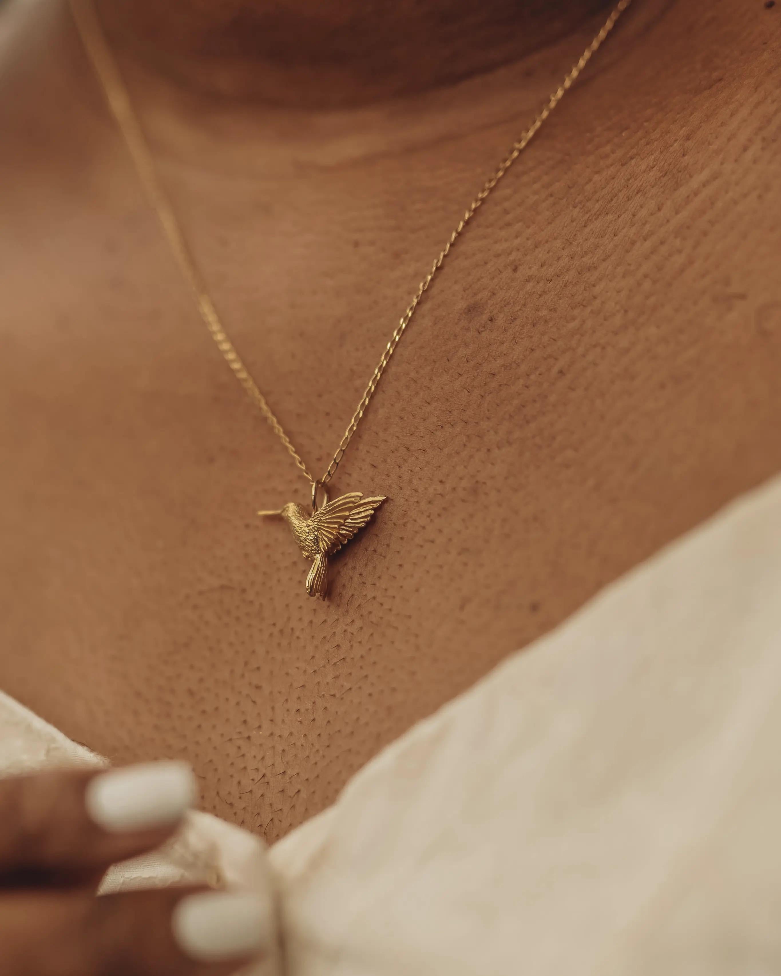 This detailed little hummingbird pendant is cast in solid 18 Carat gold and finished by hand, and is created from Lucy's original hand-sculpted design. 

This tiny hummingbird pendant is made in London, United Kingdom using recycled or Fairtrade