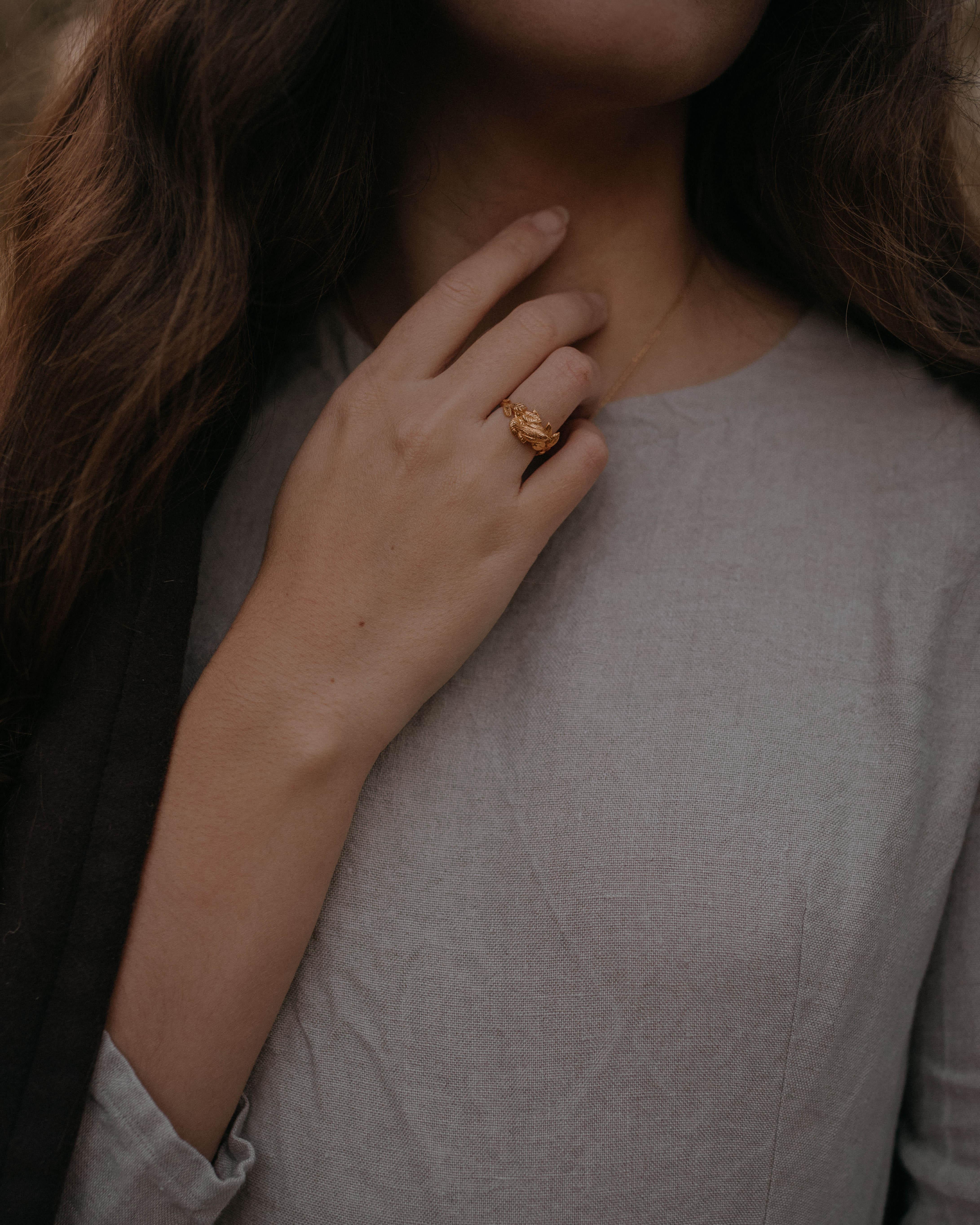 This is a delicate little ring with a branch textured band and a tiny robin perched amongst the leaves. This ring is cast in solid 18 Carat gold and finished by hand, and created from Lucy's original hand-sculpted design. 

This piece is made in
