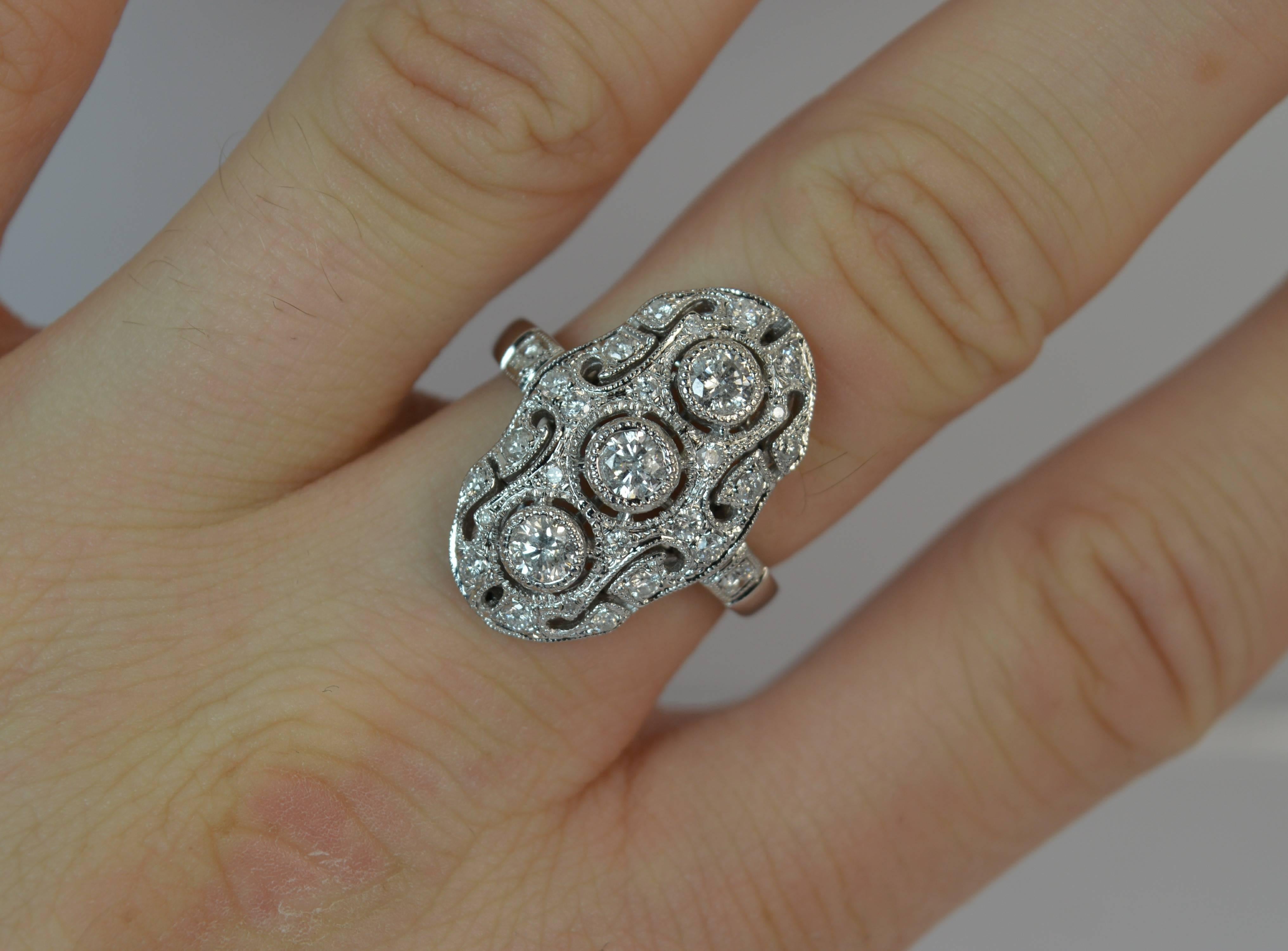 
A superb diamond cluster ring. Contemporary example of Edwardian design.

Solid 18 carat white gold example.

Designed with three round brilliant cut diamonds in grain collet settings with a pierced surround and further natural diamonds surrounding