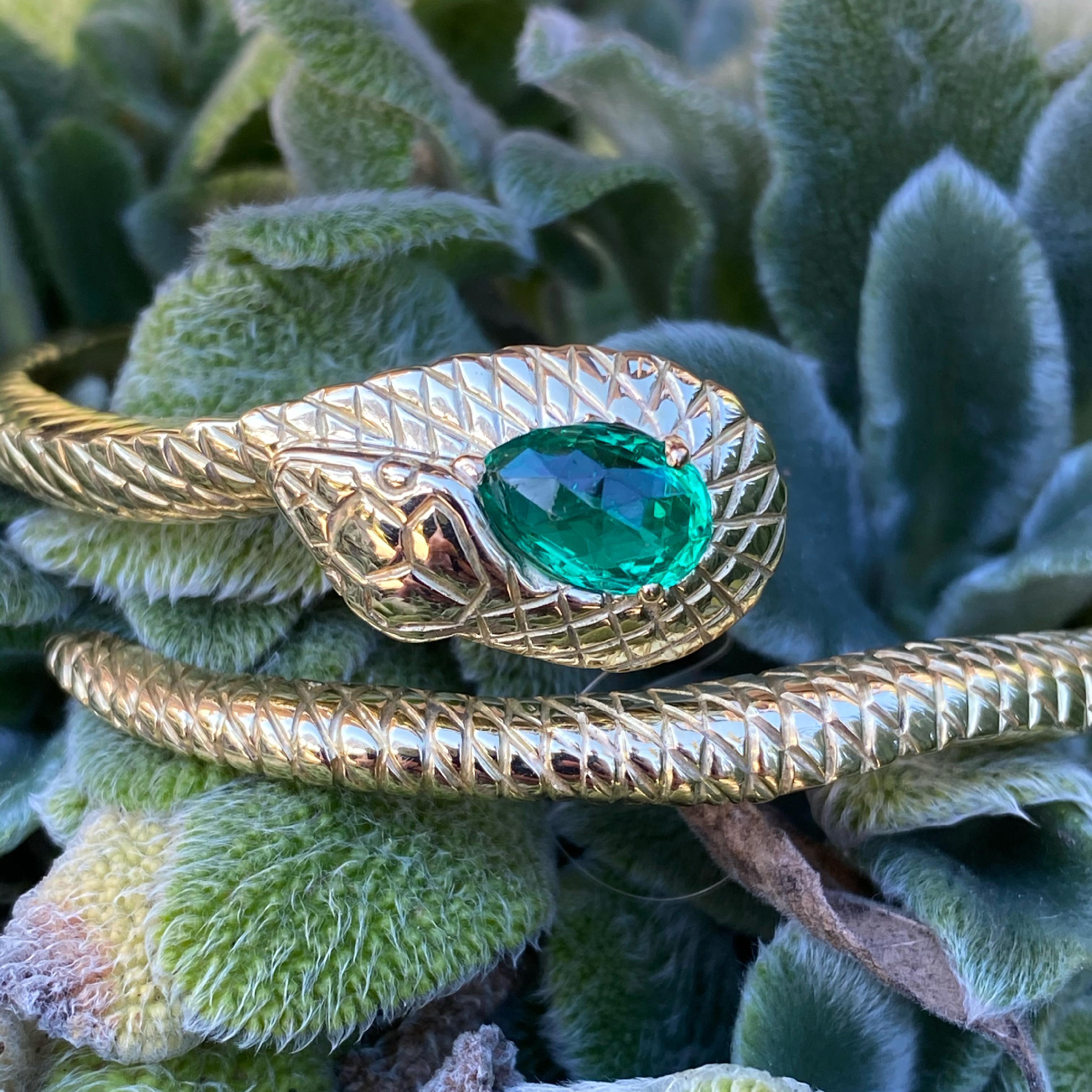 This solid gold bracelet was hand carved in Paris by a master jeweler and set with a 1.97 carat AGL certified antique no treatment Colombian emerald. It fits a medium to large wrist and can be worn higher on the forearm for smaller sizes, such as