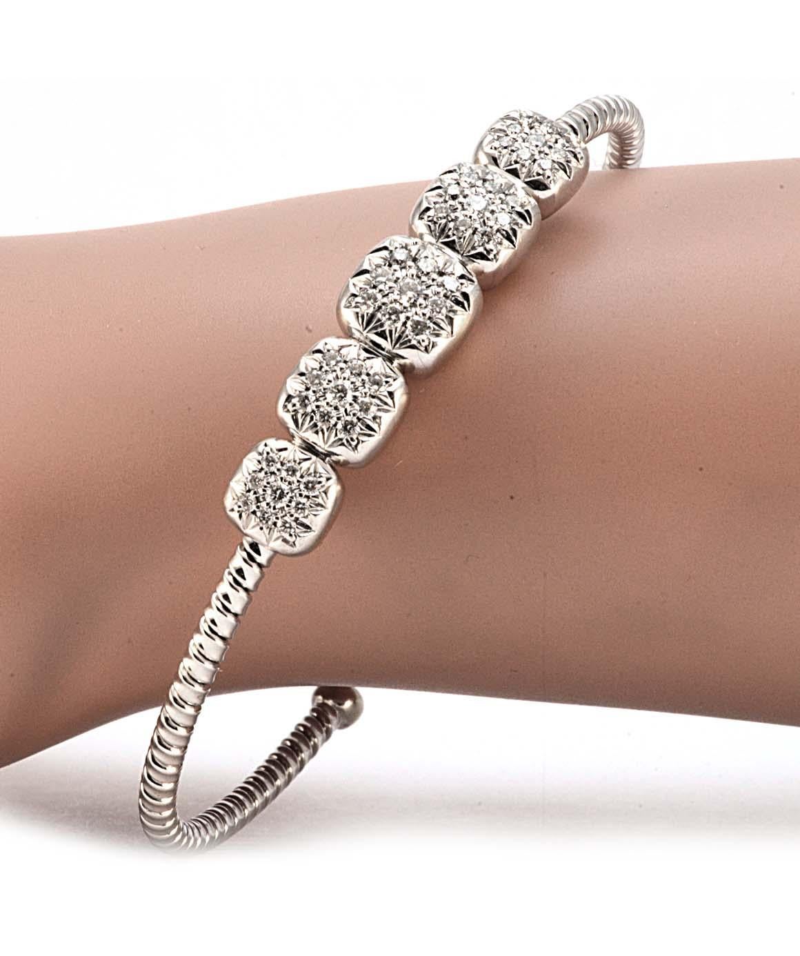 Excellent condition. This solid 18K white gold cuff bracelet features 5 cushion clusters that contain 9 genuine round diamonds each (45 diamonds total). The cuff portion of this bracelet has a cable style. The bracelet measures 2.50 inches X 2.10