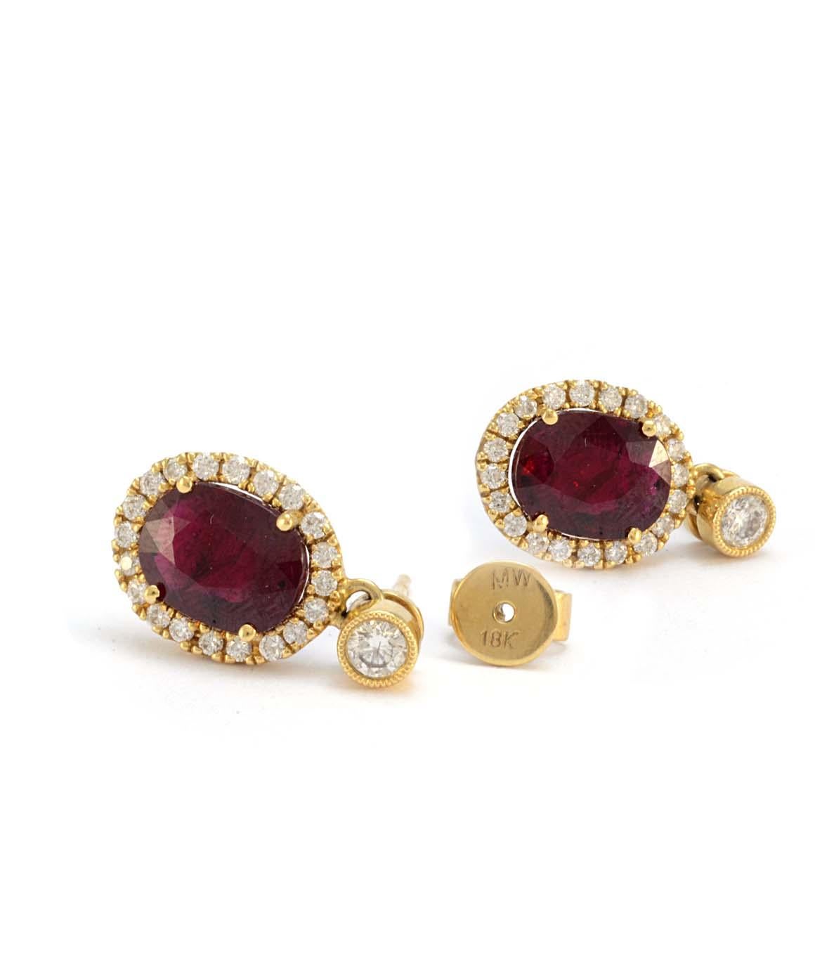 Excellent Condition. Each earring features an oval ruby measuring approximately 9.90mm X 6.67 surrounded by a halo of 20 diamonds weighing approximately 0.20cttw each. (0.40cttw total) Above each halo is a bezel set diamond weighing approximately