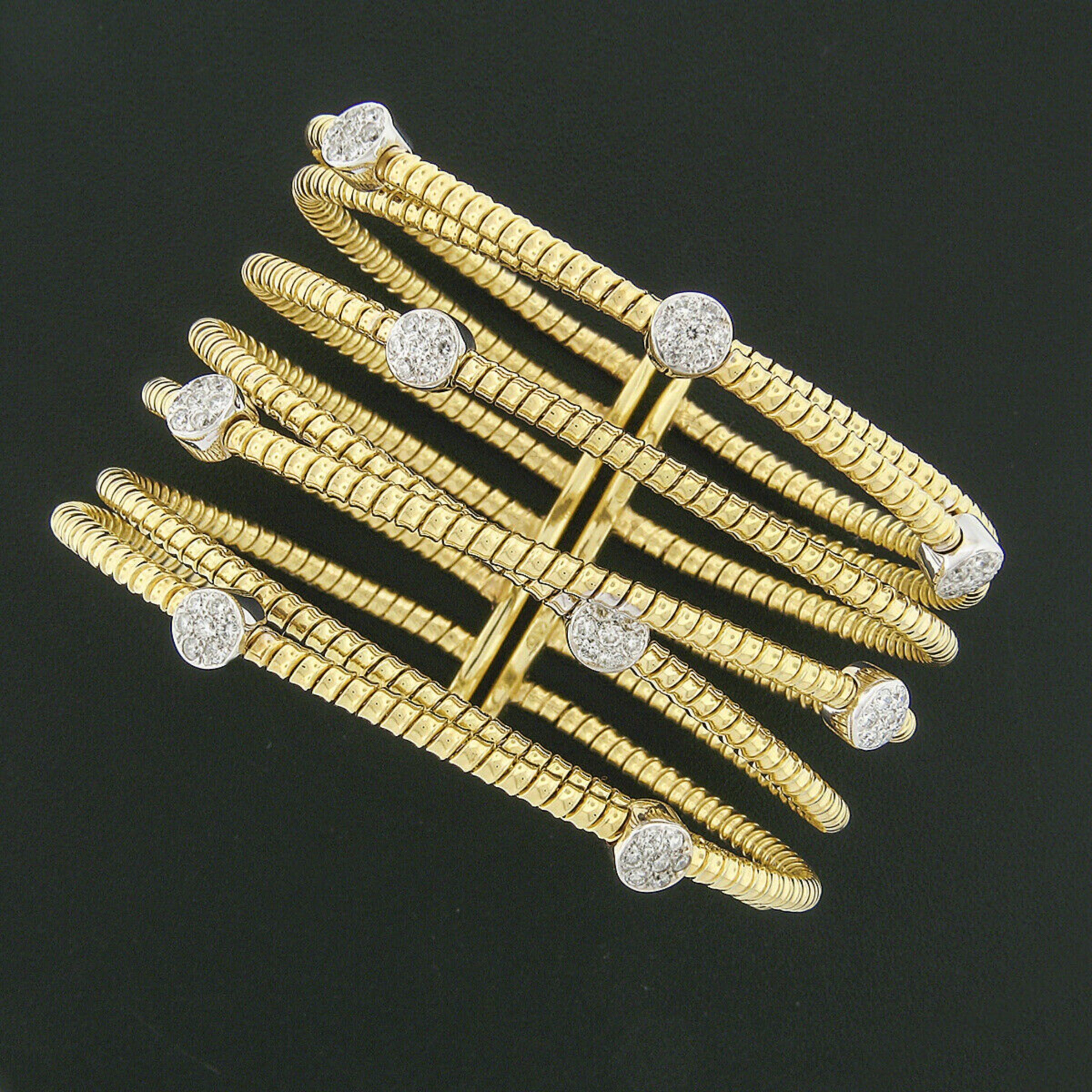 Here we have a very lovely wide open cuff bracelet crafted in solid 18k yellow gold with white gold accents. The wrapped cable crossover design features 63 pave set round brilliant diamond as 9 separate and perfectly placed clusters in solid white