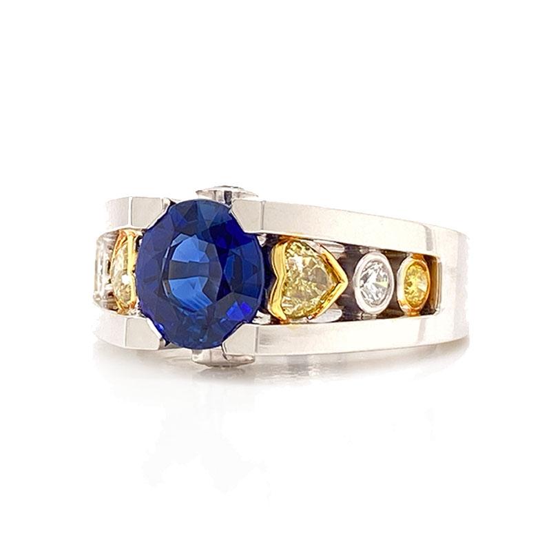 Solid 18K White Gold Natural Sapphire & White & Yellow Diamond Ring 12.6g
Excellent condition. This solid 18K white gold ring holds a natural blue sapphire that measures approximately 7.35mm X 6.57mm. Set in the shank are two genuine yellow heart