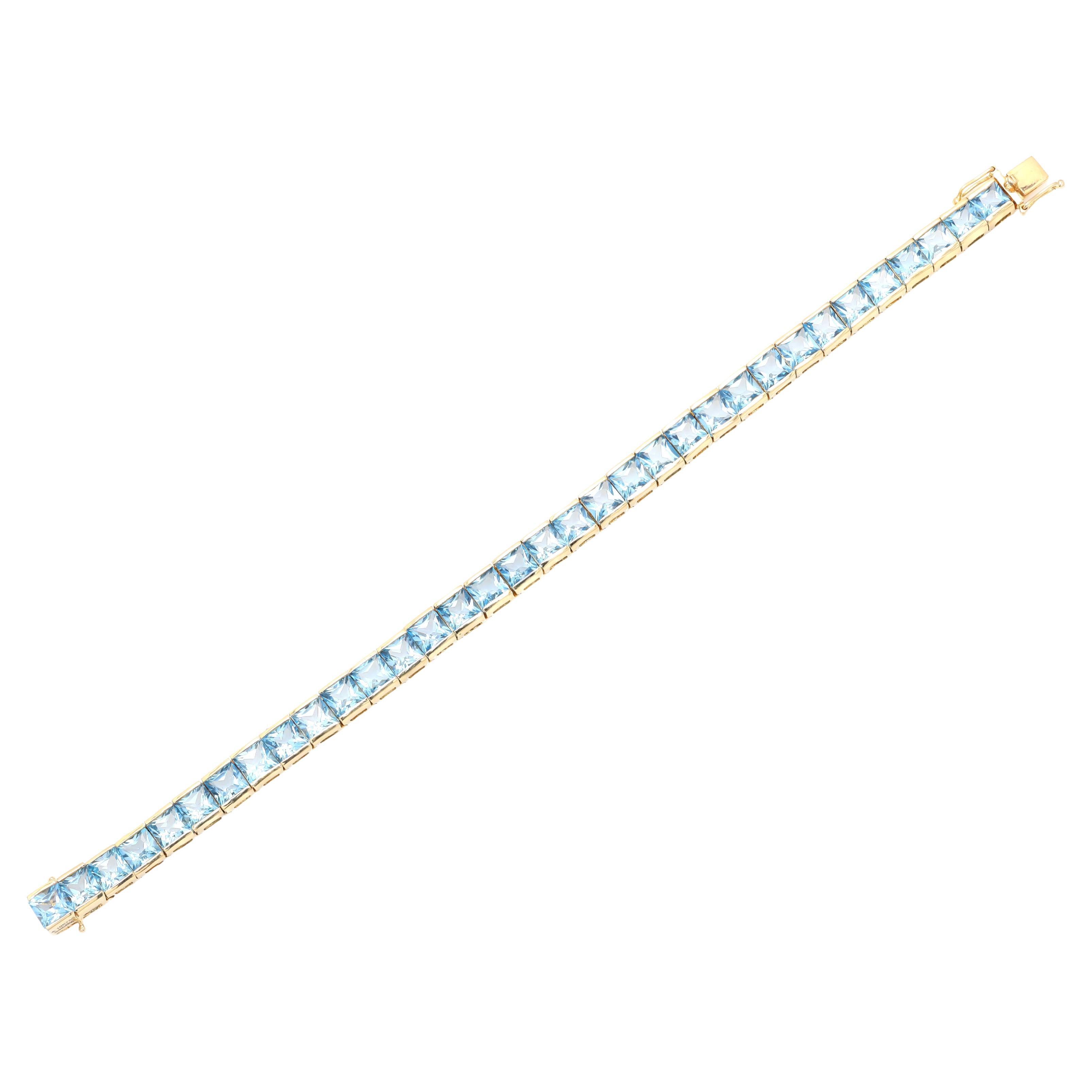 This Mesmerizing Blue Topaz Tennis Bracelet in 18K gold showcases 34 endlessly sparkling natural blue topaz, weighing 13.65 carat. It measures 7 inches long in length. 
Blue topaz provides inner peace and mental stability.
Designed with perfect