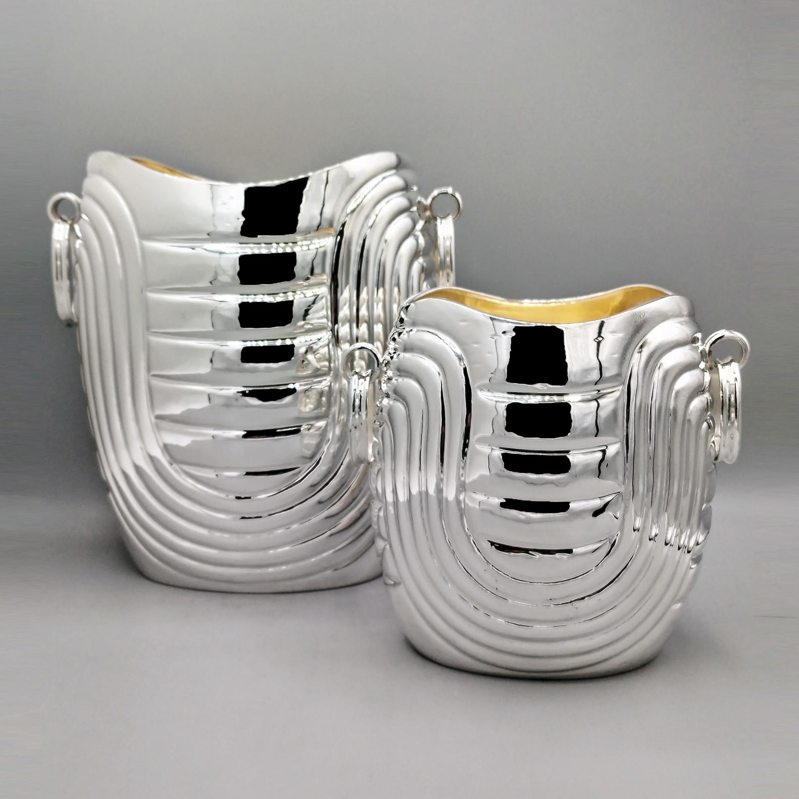 Secchiello per champagne e secchiello per il ghiaccio in argento massiccio con interno in oro 24kt.
Il corpo ovale è completamente cesellato con sinuosi disegni a strisce.
I manici sono realizzati con anelli ovali mobili che passano attraverso un