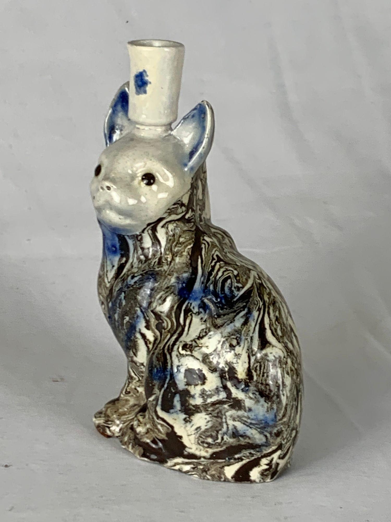 This solid agateware cat was hand-crafted in Staffordshire, England, around 1770 from laminated salt-glazed stoneware. 
An exceptional example of 18th-century English ceramics, it combines the technical innovation of early stoneware with the charm