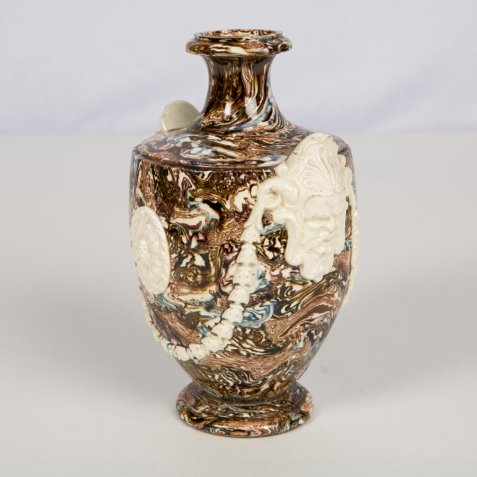 This 18th century small vase is a gem of solid agateware.  It was made of compositions of pigment-infused clay that look as much like natural stone as the stone itselfIt. The process involved wedging the colored clays together to form a solid agate