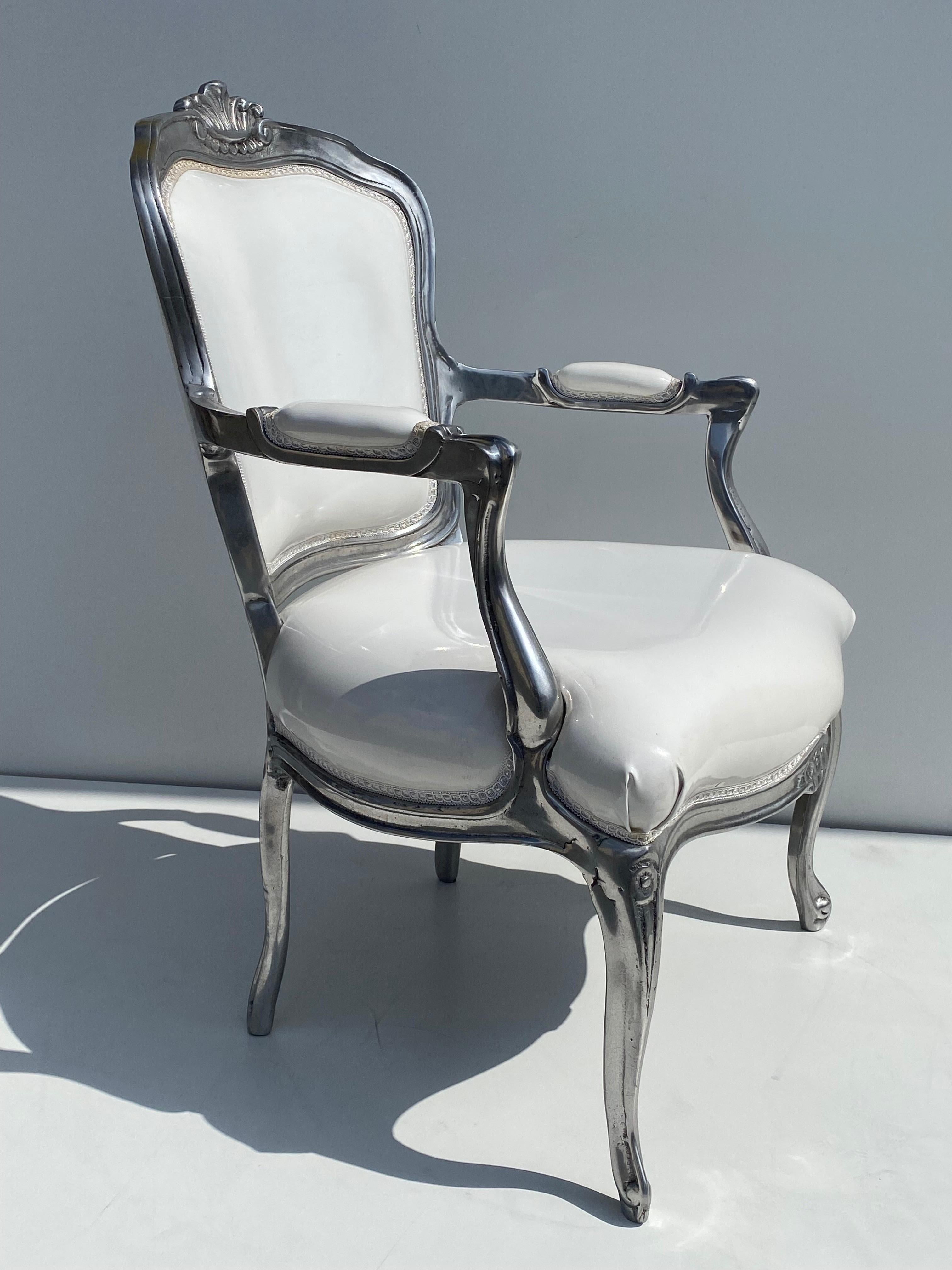 Solid cast aluminum Italian bergere chair in white vinyl.
