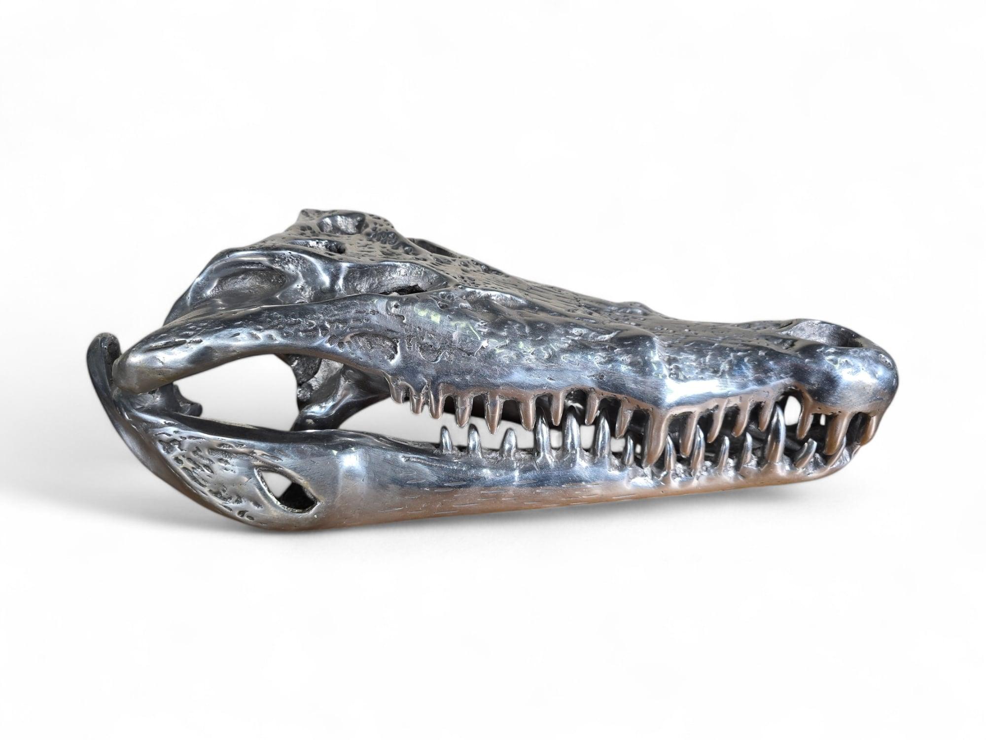 
An impressive sculpture of a crocodile head crafted from solid aluminum, dating to the 1980s. The piece features a movable jaw and is mounted on a sleek black wooden base, adding a modern yet bold touch to its display. The craftsmanship and