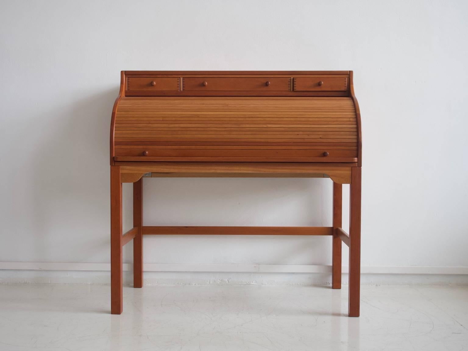 Andreas Hansen writing desk or secretary made of solid American cherrywood. Designed in 1979. Manufactured by Hadsten Wood Industry. Top part with three small drawers, front with tambour door, behind which are small compartments and drawers.