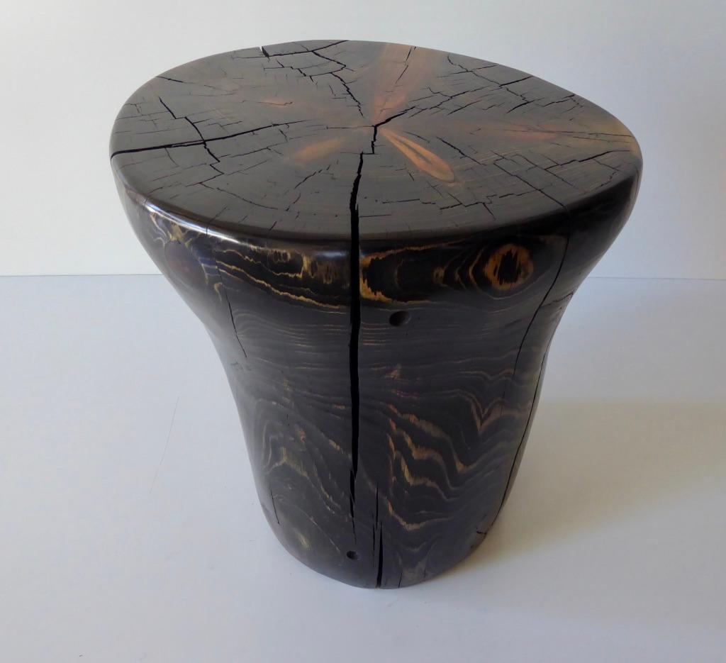 An ebony-stained solid pinewood taboret/table by contemporary American artist Daniel Pollock. Dan hand-selected this sculptural piece of reclaimed pine wood that has been dried and carved to highlighting the wood grain grain. This sculptural piece