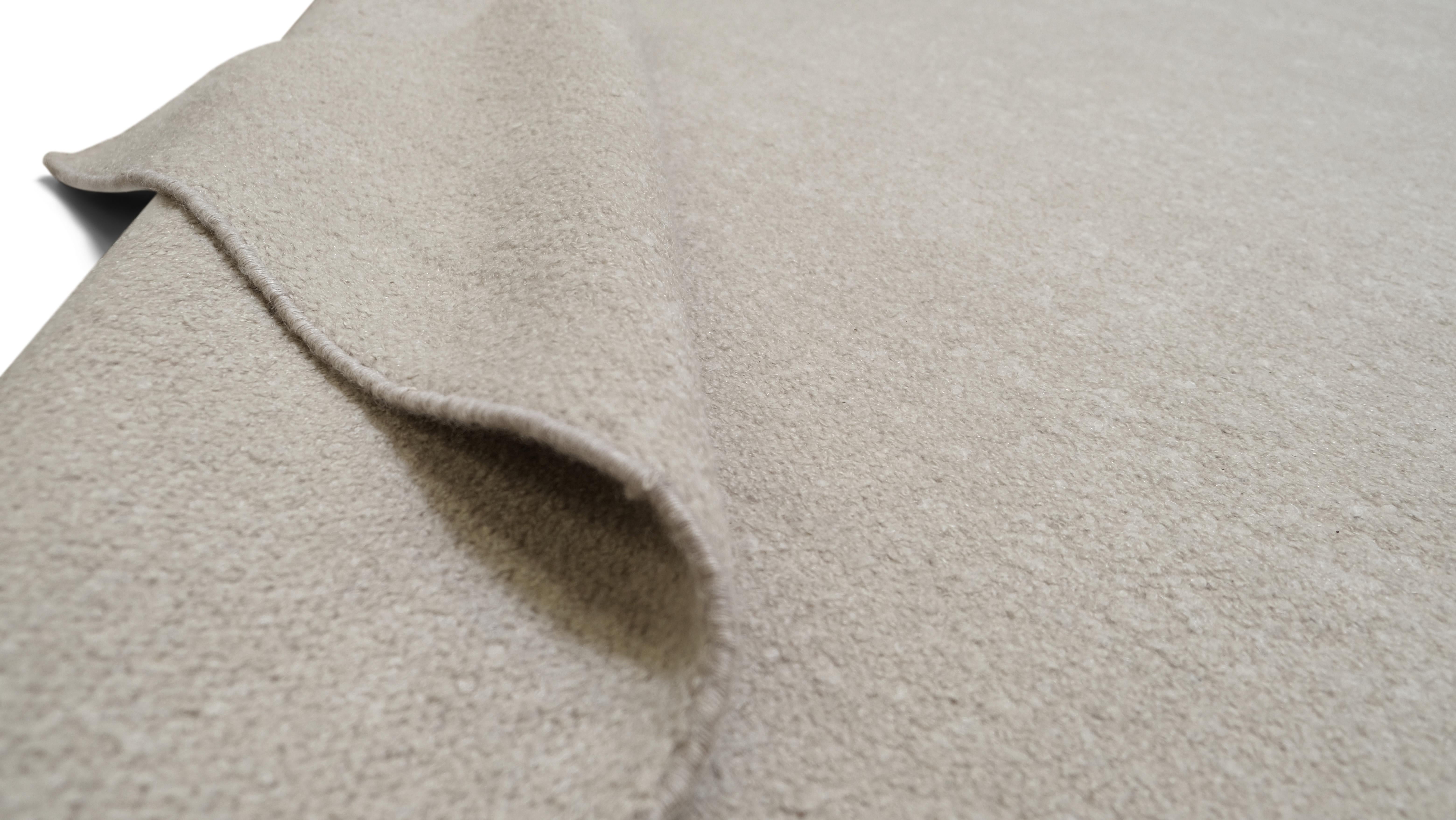 Verwandeln Sie Ihren Wohnbereich mit diesem eleganten, handgeknüpften Wollteppich in einem neutralen Boucle-Design, das Schlichtheit und Raffinesse ausstrahlt. Die subtile Textur und die klare, minimalistische Ästhetik machen diesen Teppich zu einer