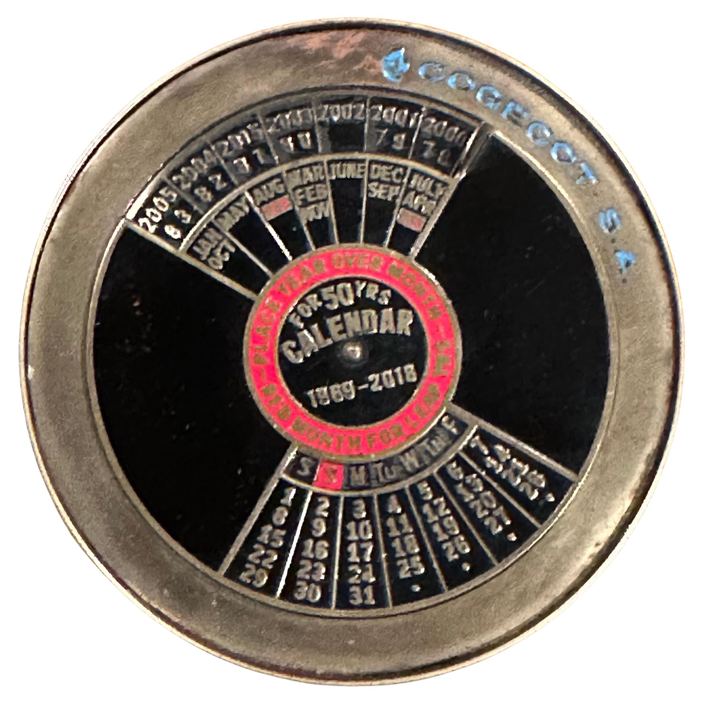 Geniales Zifferblatt / Briefbeschwerer mit 50-jährigem ewigem Kalender aus massivem Messing und Emaille von Cogecot S.A., ca. 1969.  Das Stück ist so konzipiert, dass es den Wochentag für jedes beliebige Datum zwischen 1969 und 2018 bestimmen kann. 