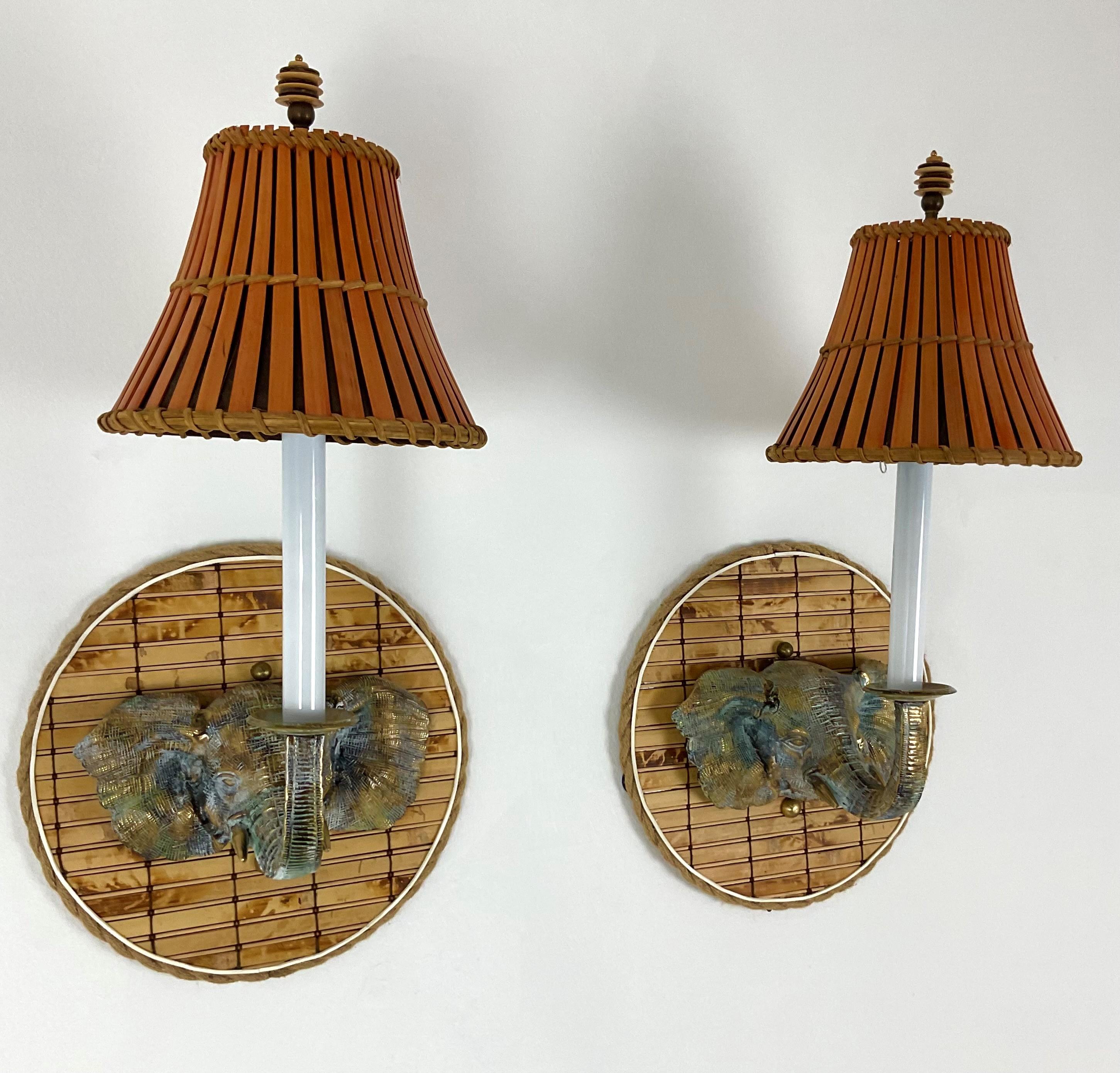 Elephant Heads with Trunks up are made of solid cast brass with a beautiful patina finish. The back plate is made of natural bamboo leather and rope. Bamboo shades with coconut finals complete the look. These are one-of-a-kind pieces.