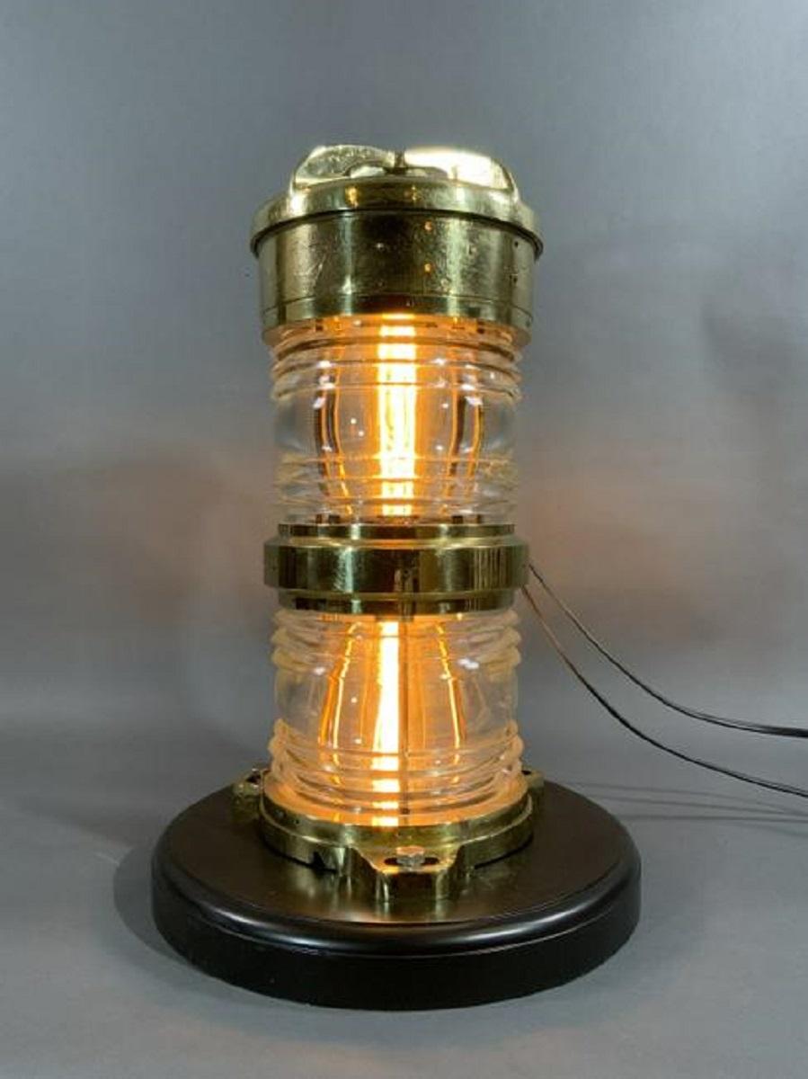 Brass beacon light that has been meticulously polished and lacquered. Fitted with two Fresnel lenses. The smooth brass glows with the lacquer finish. Wired with electric. Crown top. Mounted to a thick mahogany base.

Overall dimensions: Weight is