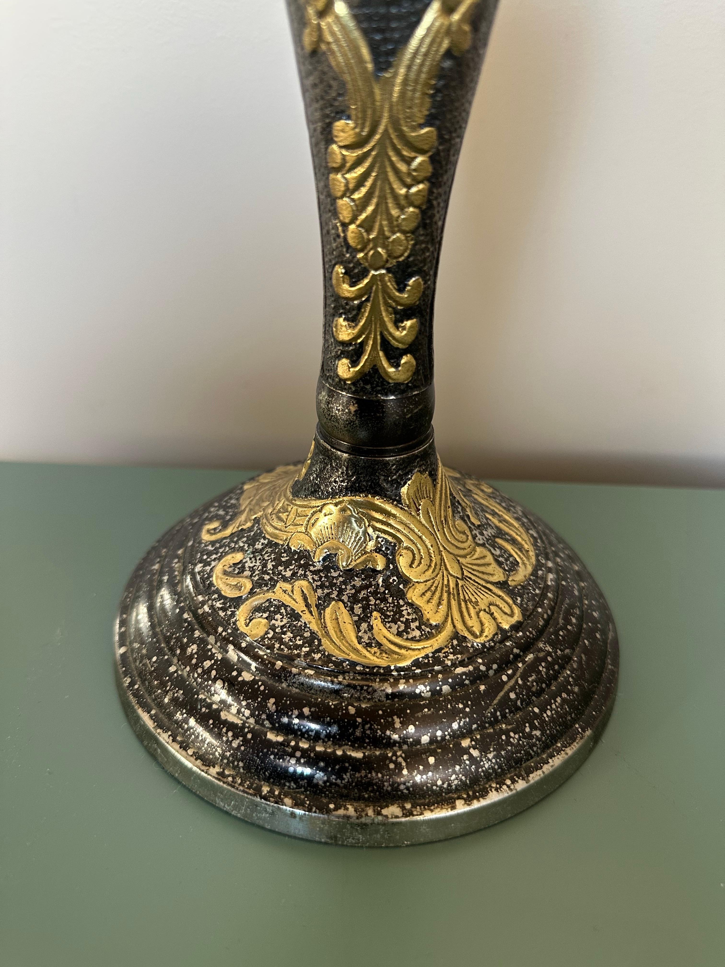 Dies ist ein Vintage-Kerzenhalter aus Messing und schwarzer Emaille mit einem verschnörkelten, klassischen Design. Das Stück hat einen hohen, schlanken Stiel, der in einen breiten, abgerundeten Sockel übergeht und für Stabilität und Gleichgewicht