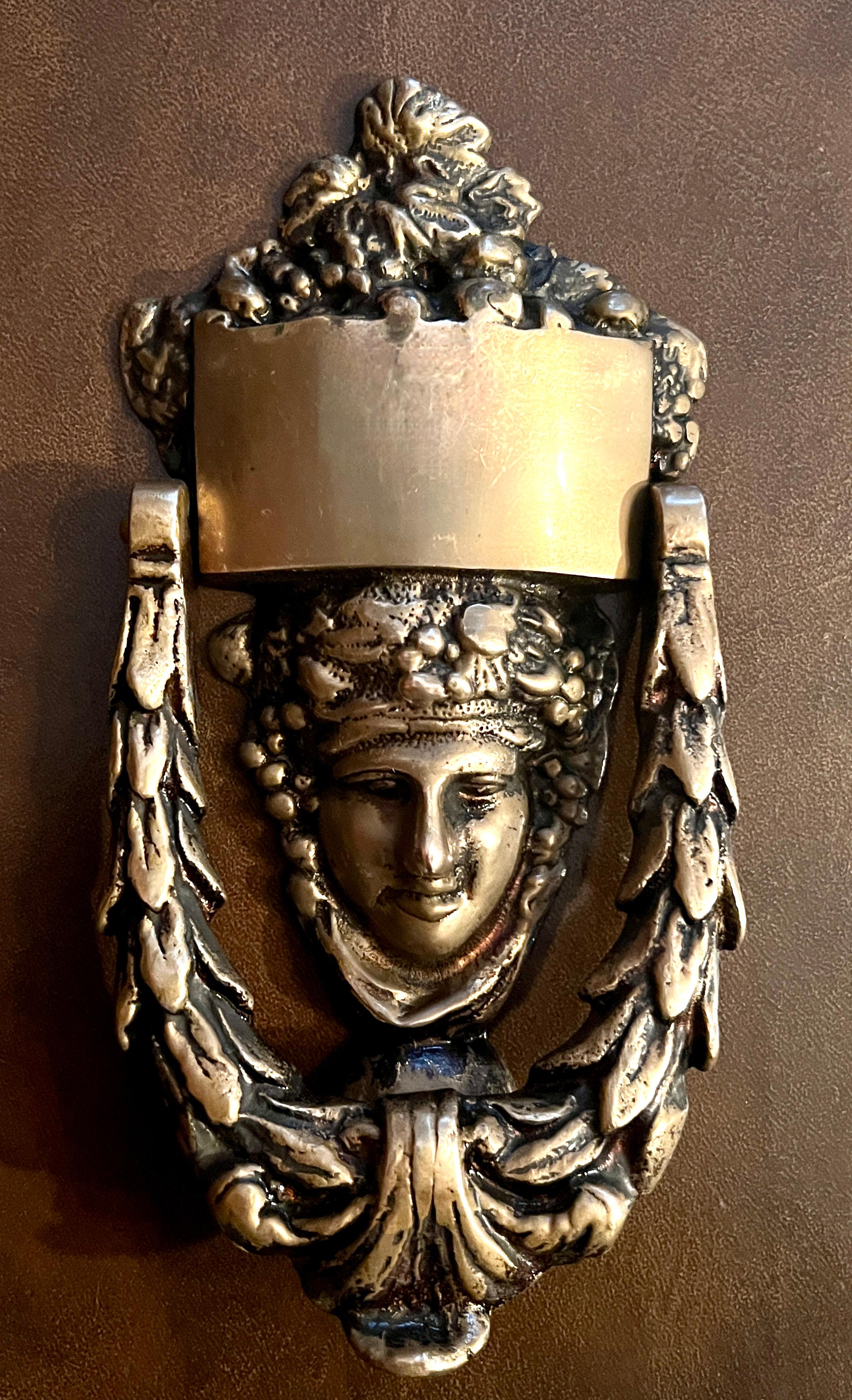 A Victorian Solid Brass Door Knocker with the face of Roman Goddess Dionysus.

The pieces is solid, well made and a compliment to many spaces or Doors.   The top has a band that could be engraved with a name or initials.

A perfect piece for the