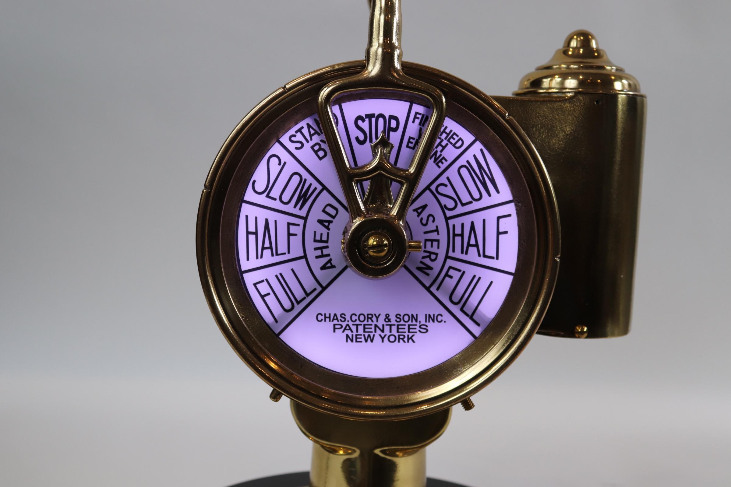 Solid brass ships engine order telegraph with faceplates from Charles Cory & Son, Inc., New York. With modern wiring for home display. Mounted to a thick wood base with rich dark finish. Weight is 28 pounds.