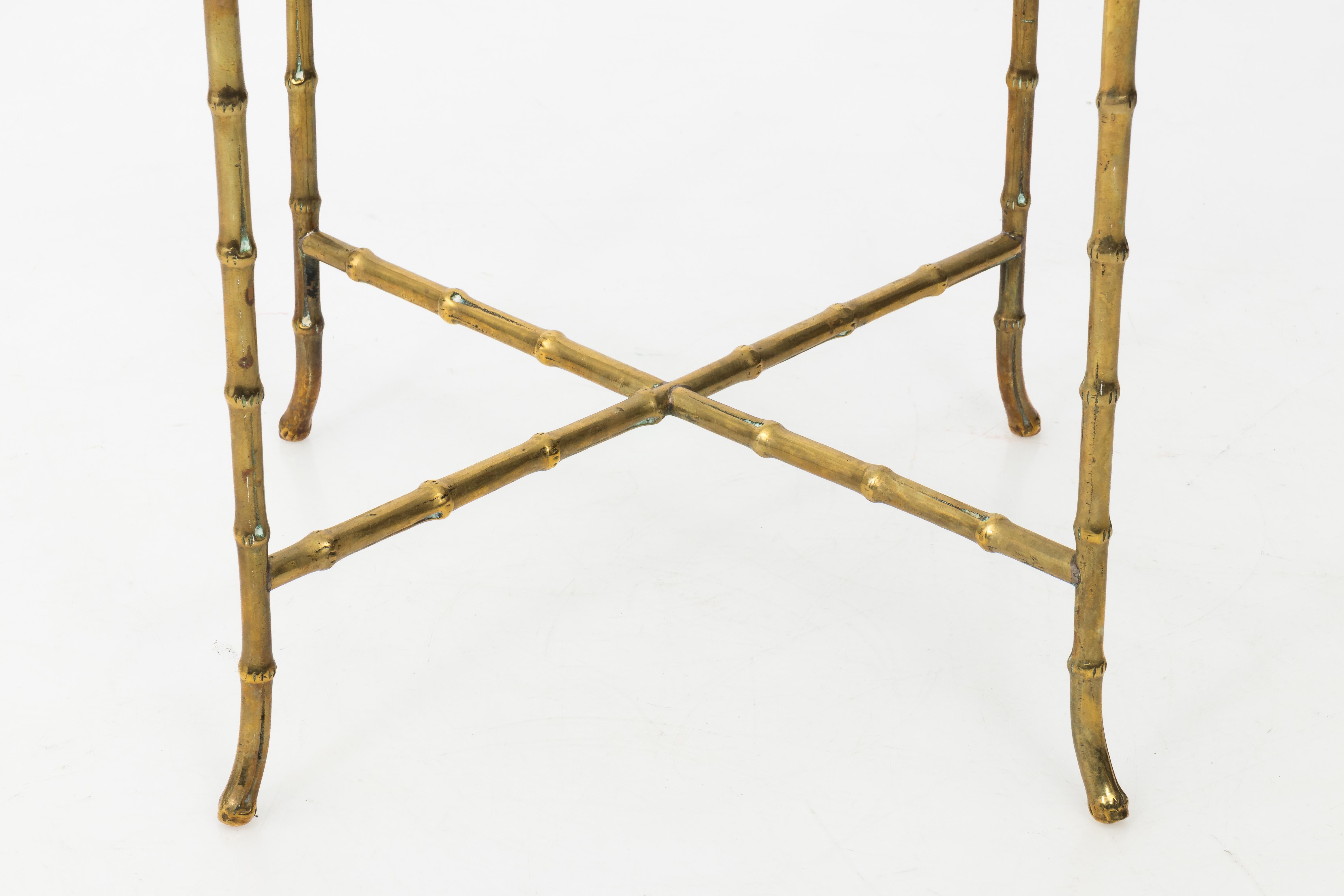 Heavy solid brass faux bamboo side table with square glass top and turned out feet in the manner of Baguès. French, circa 1960. New glass top.