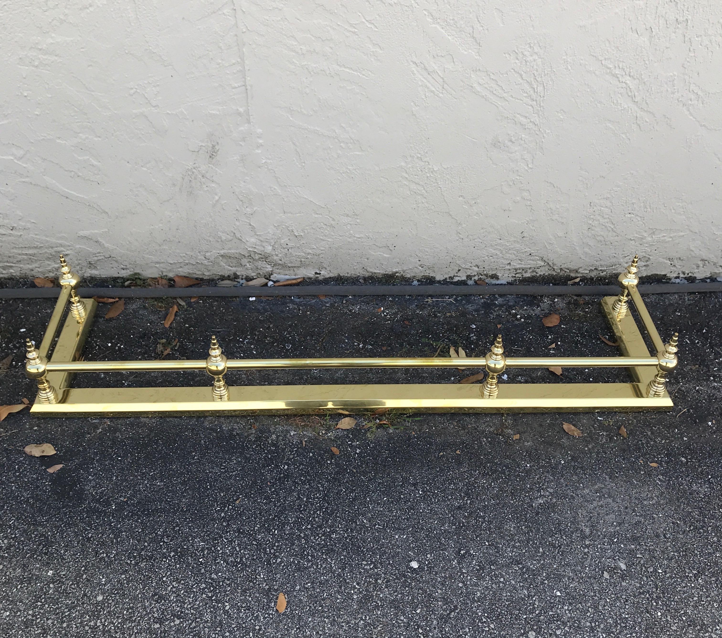 Solid brass fireplace fender with six finials.