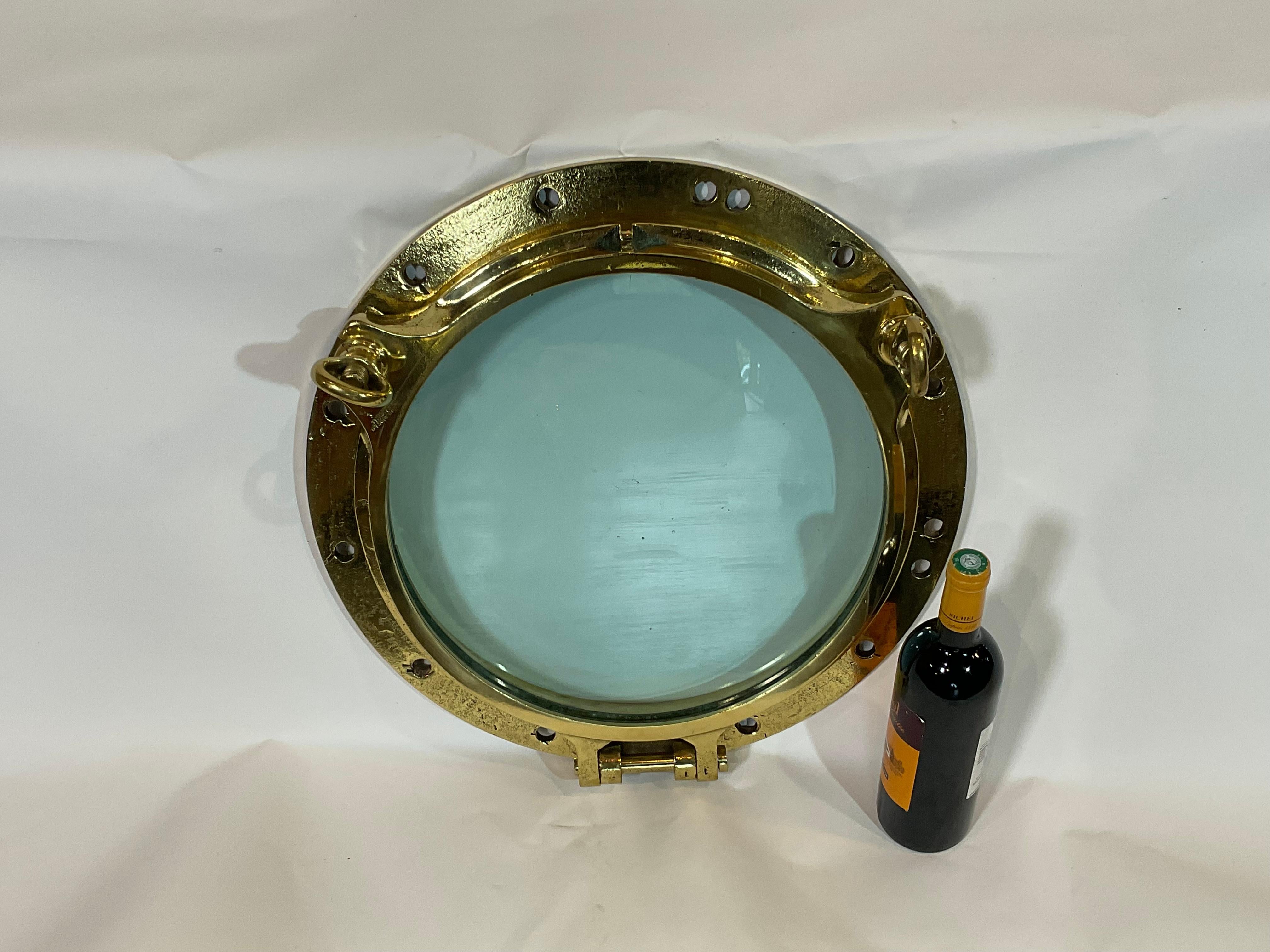 Highly polished ships porthole of solid brass with lacquer finish. Fitted with glass. This is by John Roby Limited of Rainhill. Roby produced portholes for the grand liner including Titanic.

Weight: 45 LBS
Overall dimensions: 5” height x 20”