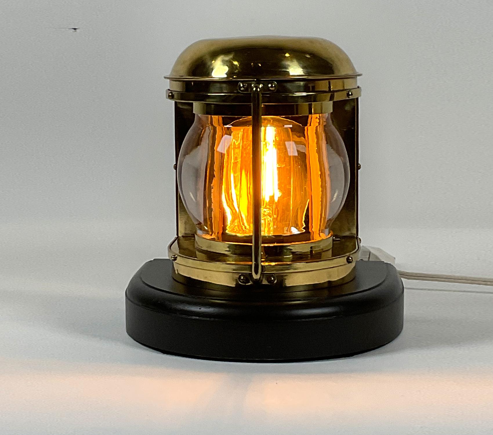 Ships lantern with beautiful dioptric lens and protective brass bar. Meticulously polished and lacquered. Mounted to a thick mahogany base and wired for home use. 

Weight: 6 LBS
Overall dimensions: 10