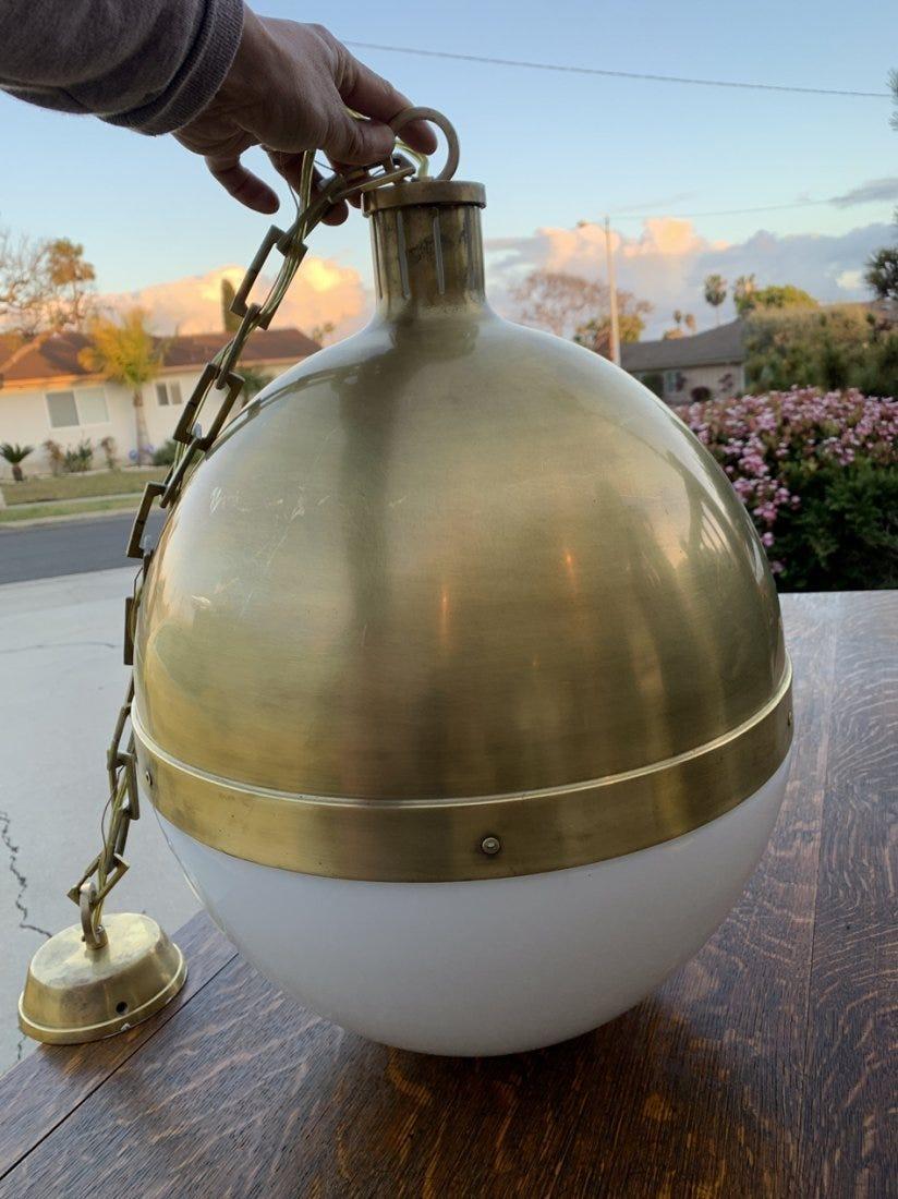 Beautiful chandelier made in solid brass with a milkglass shade.
The metal has a beautiful aged patina and the glass in free of cracks.
The piece comes with the original brass canopy and chain.

Measurements:
47 inches high x 16 inches in