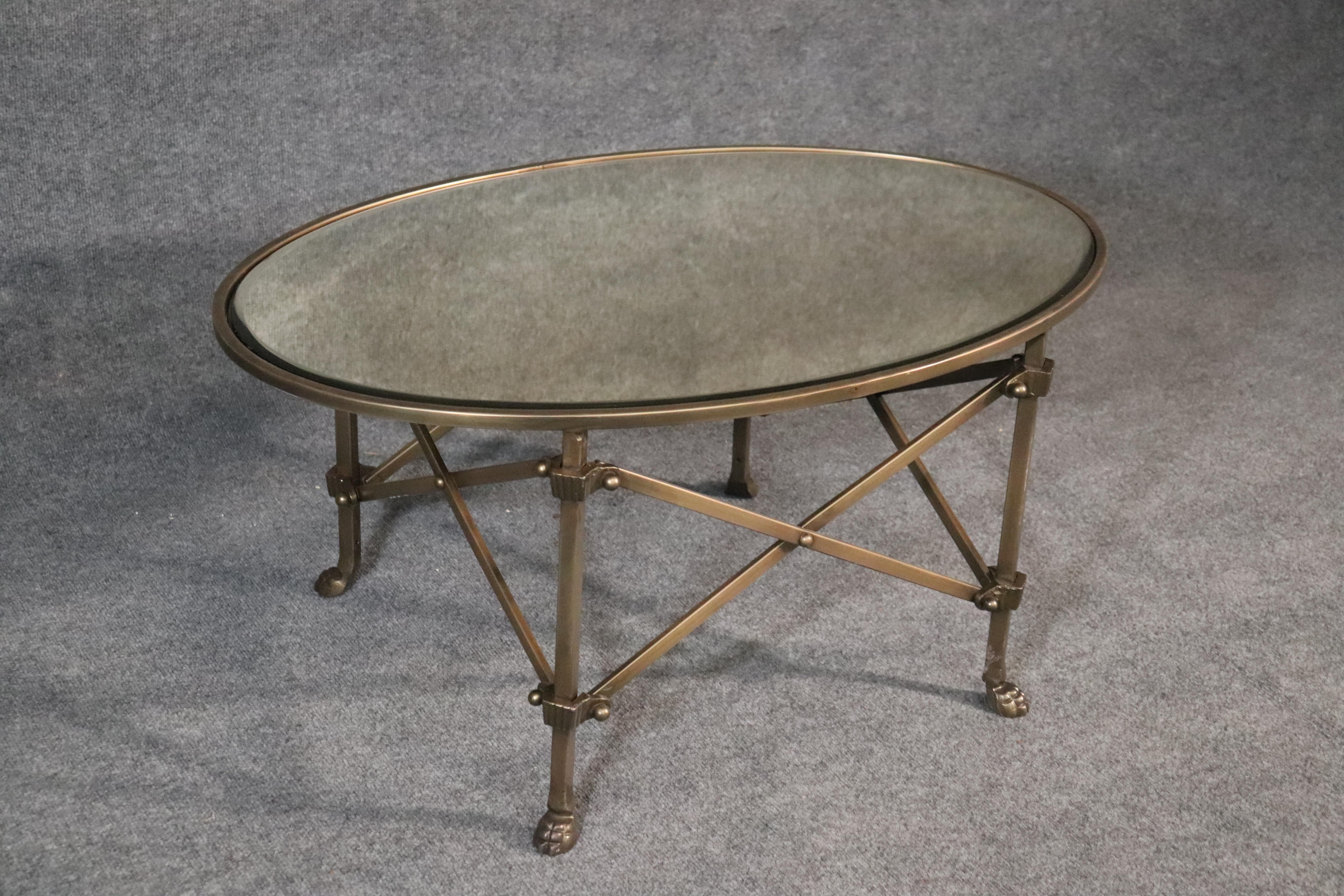 This is a gorgeous sold brass coffee table with a perfect mirrored top. The table has beautiful lines and is sleek and sophisticated with paw feet and architectural links on the base. The table measures: 36 wide x 24 deep x 17 tall.