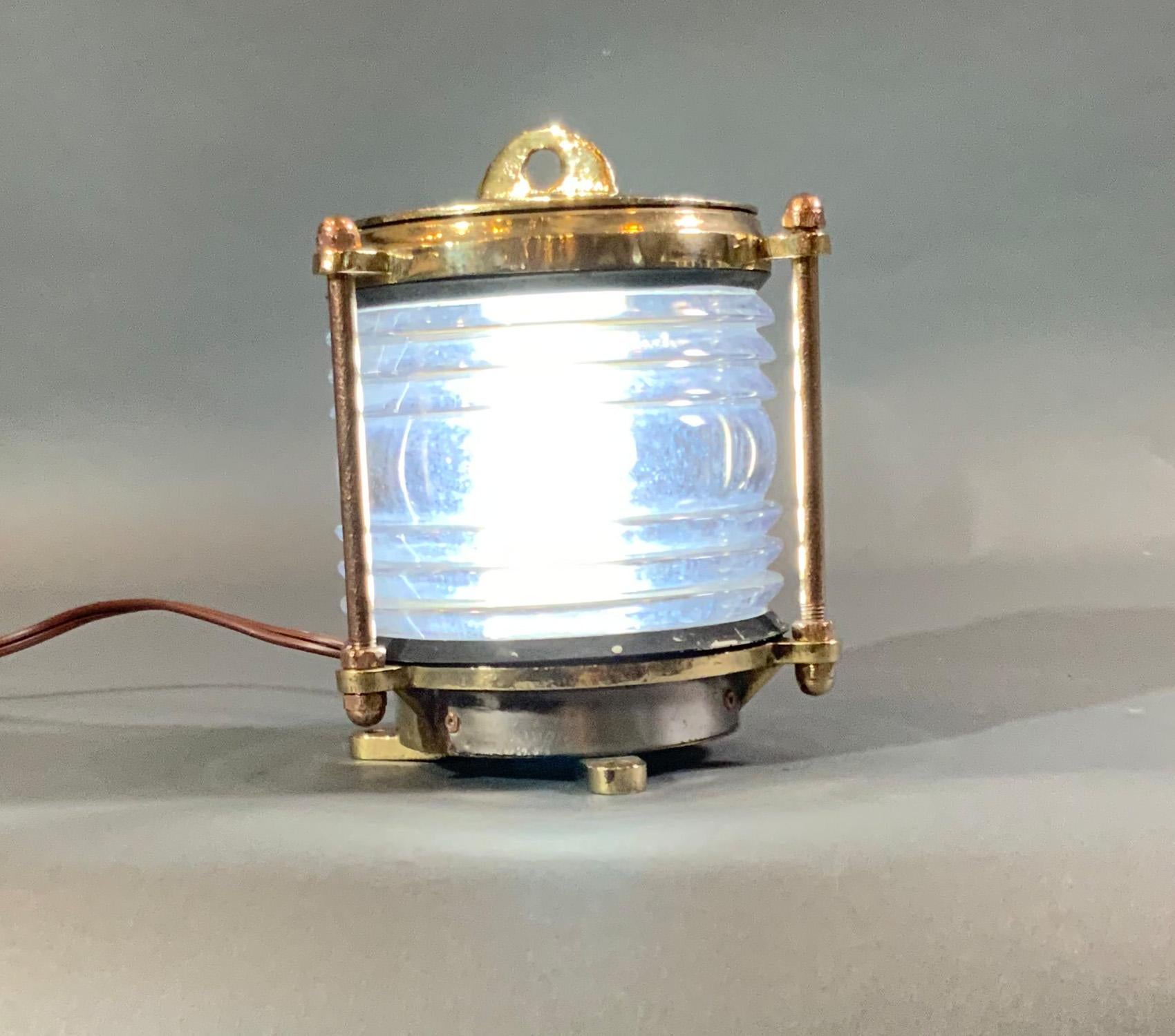 Solid brass dock light with clear glass Fresnel lens. Wired with electricity. Three flange feet for mounting.

Weight: 6 LBS
Overall dimensions: 8” H x 7” D
Made: English
Material: Brass
Date: Circa 2000.