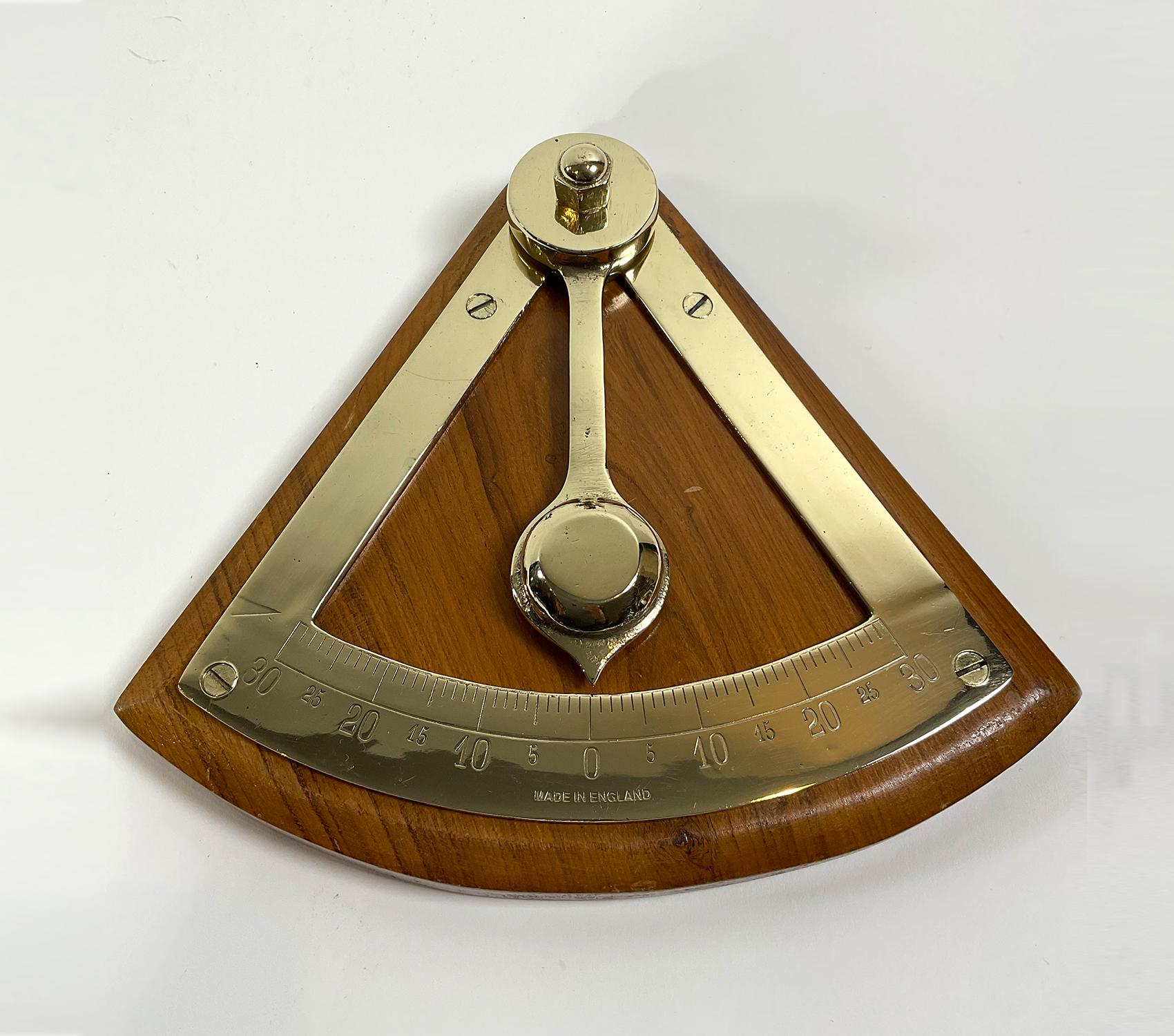 Brass inclinometer from a ship or yacht. Mounted to a thick wood backboard. The engraved scale measures to a thirty degree pitch. Heavy brass pendulum. Circa 1980. Freshly polished.