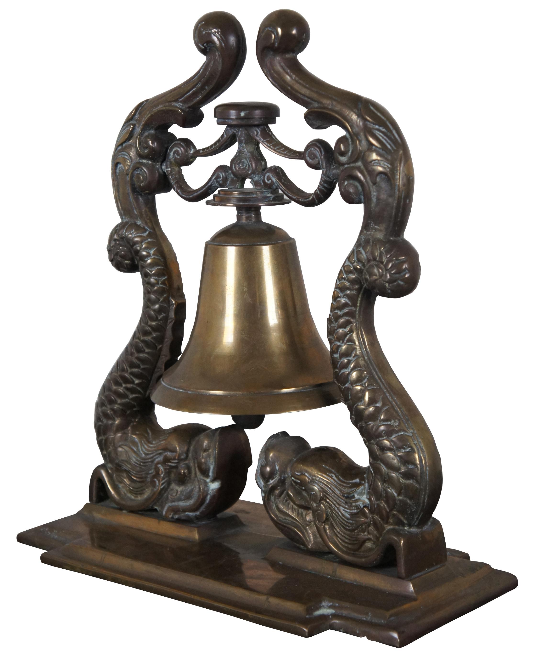 Ornate brass navy bell
Features two dolphins supporting a bell on intergal molded base. Bell is functional, and has loud tone. 
This is the type of bell that was used on ships in the 19th century and was adopted by the US Navy as an insignia in
