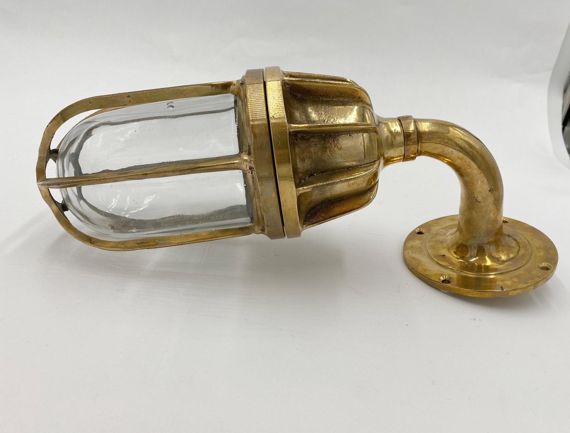 Solid brass ship sconce with a 90 degree bend, vane top, and glass globe. Cleaned and rewired. Small quantity available at time of posting. Please inquire. Priced each. Please note, this item is located in one of our NYC locations.