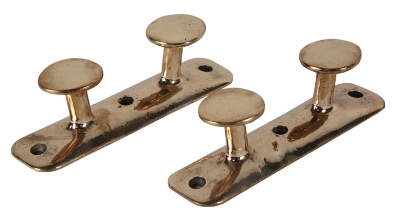 Solid brass ships cleats, circa 1980s. These make handsome coat hooks or bathroom towel holders when mounted on the wall. For the boater in your life, these make a nice object d'art. Priced individually.