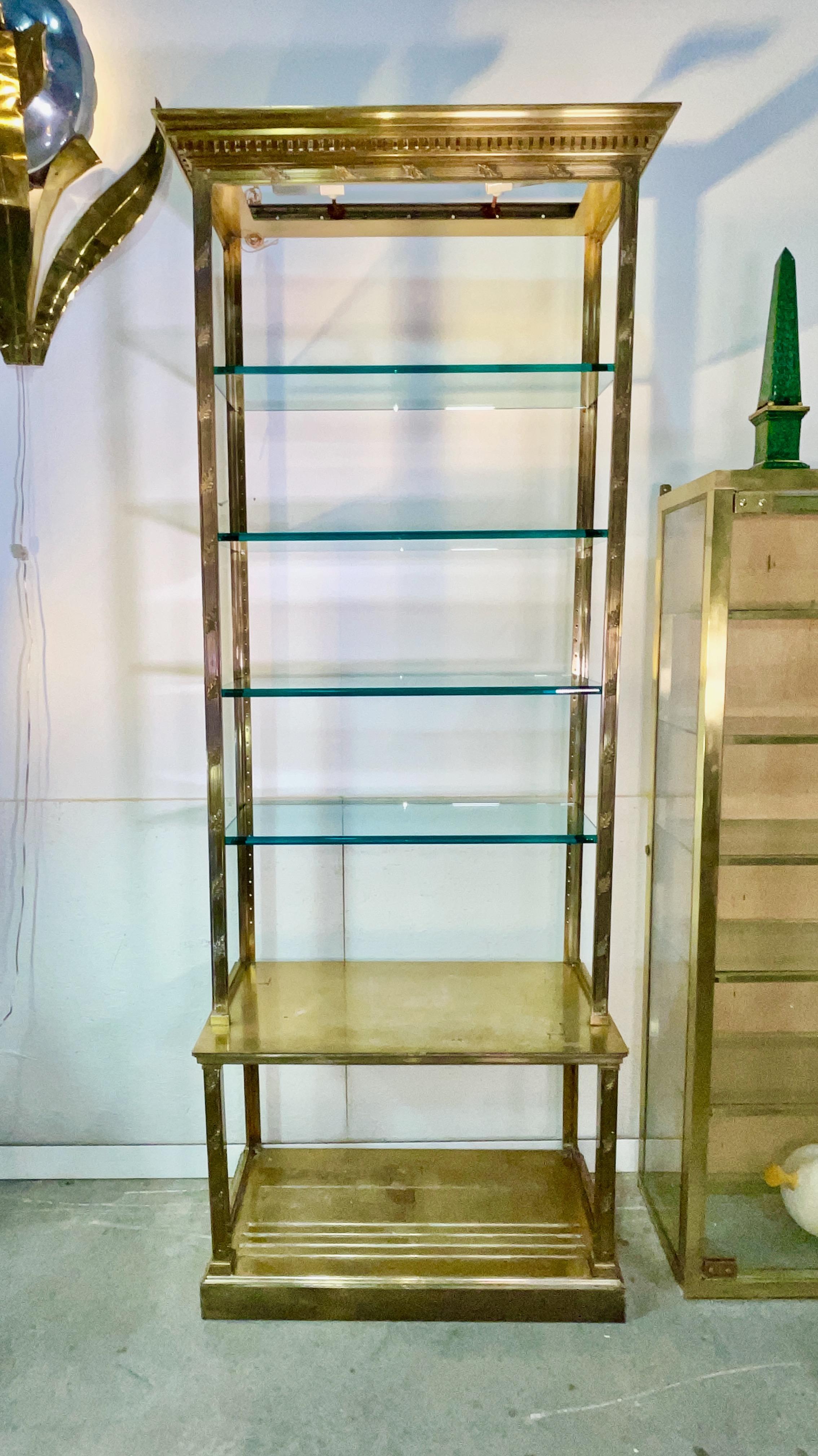 Étagère ou vitrine de style néoclassique en laiton massif sur pied, la corniche denticulée sur un cadre cannelé orné de feuilles. Equipé d'étagères en verre.
Dimensions globales au plus large (entablement) et au plus profond (moulure de base) : 103