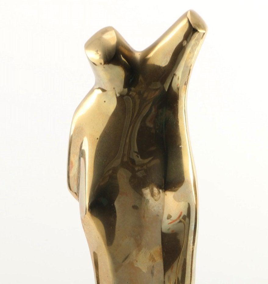 Introducing our exquisite Solid Brass Nude Female Sculpture, Circa 1960's. This captivating piece showcases the timeless beauty of the female form, meticulously crafted from high-quality brass. 

With its elegant golden hue, this sculpture