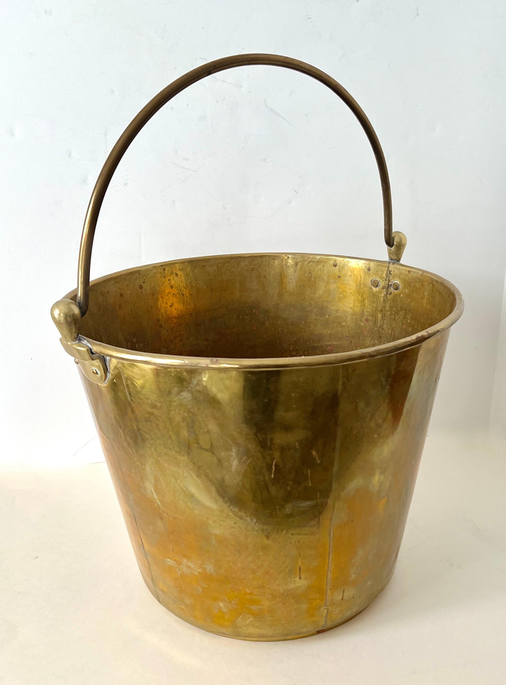 A unique pale made of brass. The handled piece has a wonderful patinated finish - while the piece could easily be polished to a high sheen, we have left the patination. 

The pale can be used in the kitchen as a waste bin, water pale, cleaning pale.