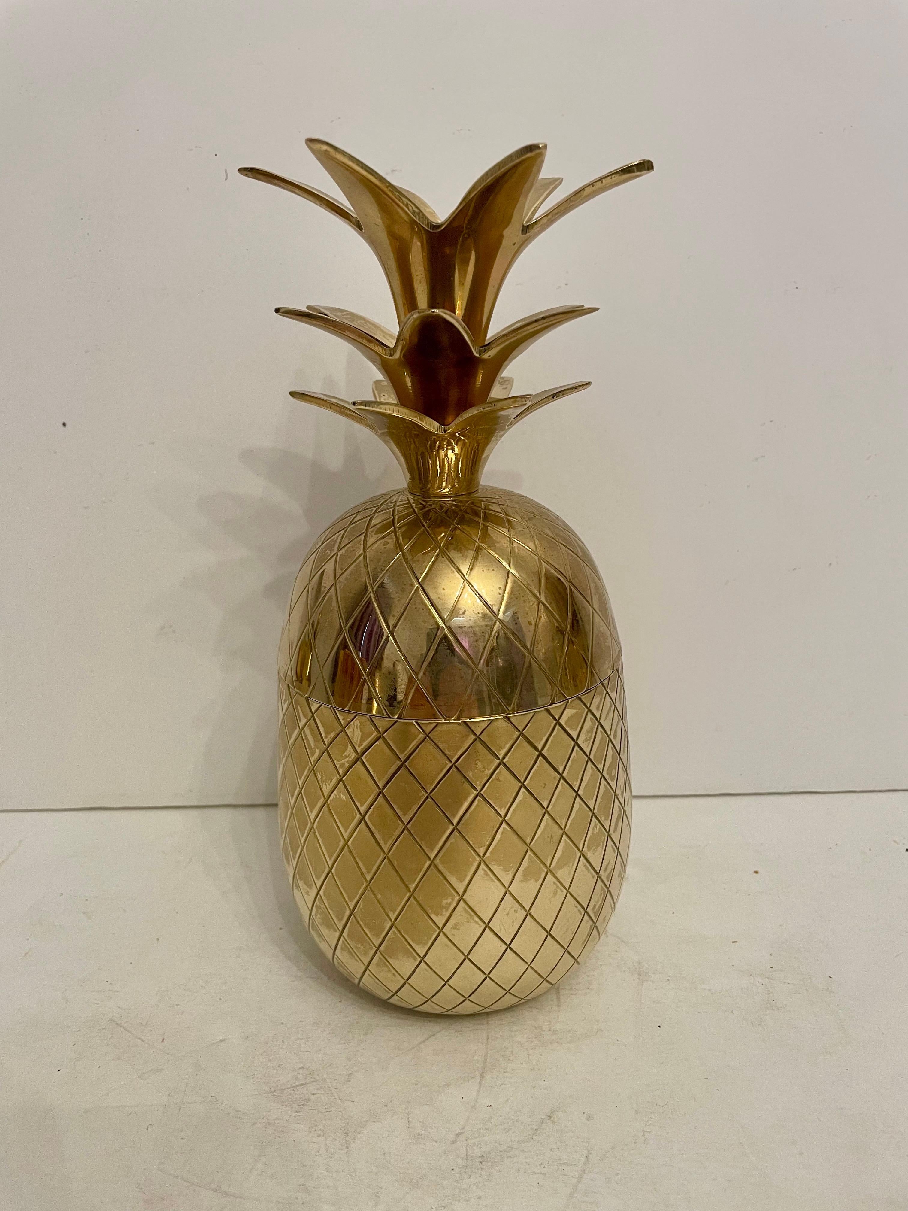 Récipient couvert en forme d'ananas en laiton. Bon état général. Les zones sombres des photos sont des reflets.  Poli à la main. 9,5