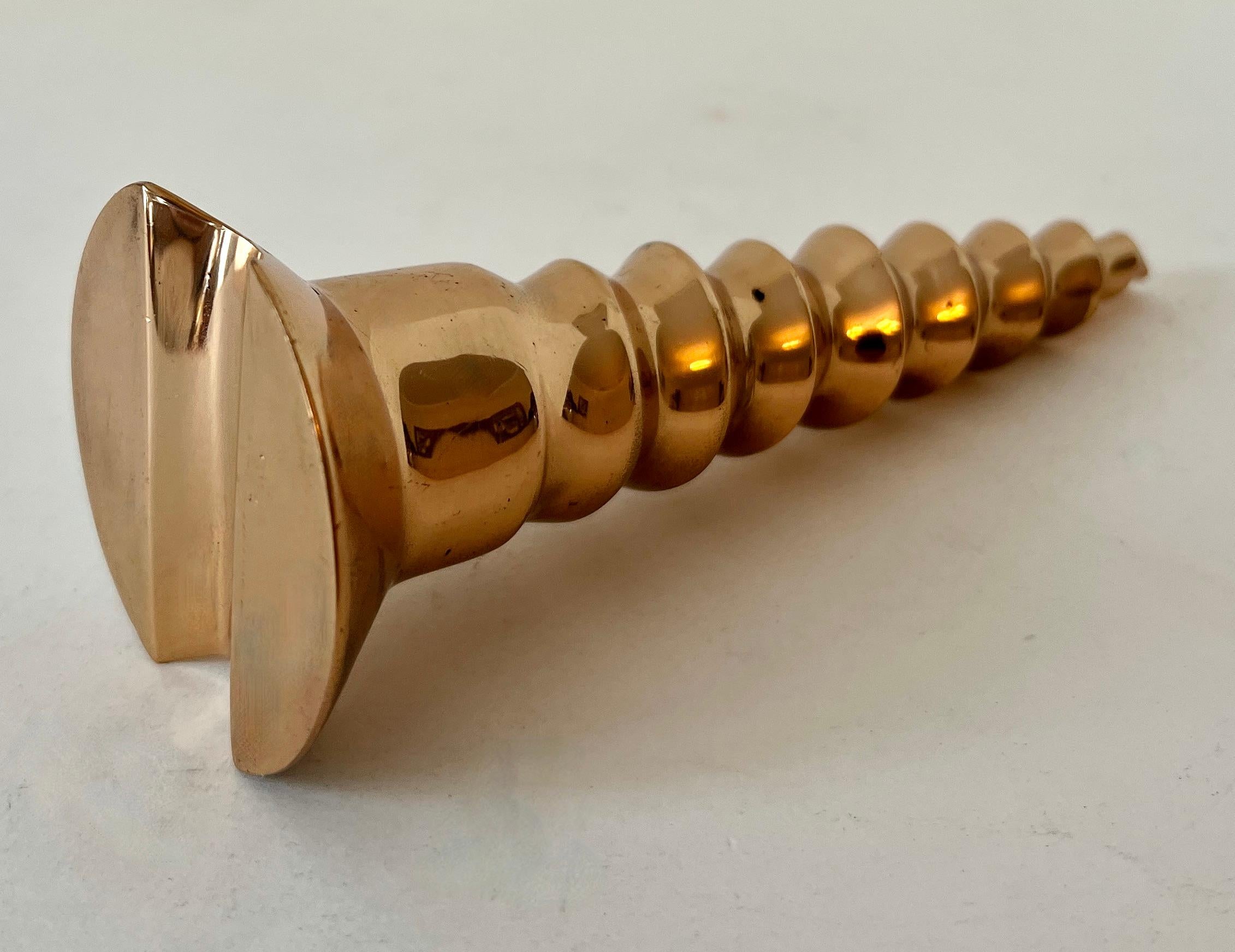 A heavy and over sized Polished brass Screw.  The piece is quite attractive and ready for any desk or work station in need of a paperweight.. whimsical and classic design.

The piece would be a compliment to any space that is, perhaps, an office for