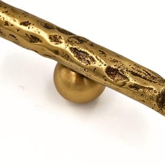 Textured brass door pull with patinated brass spheres