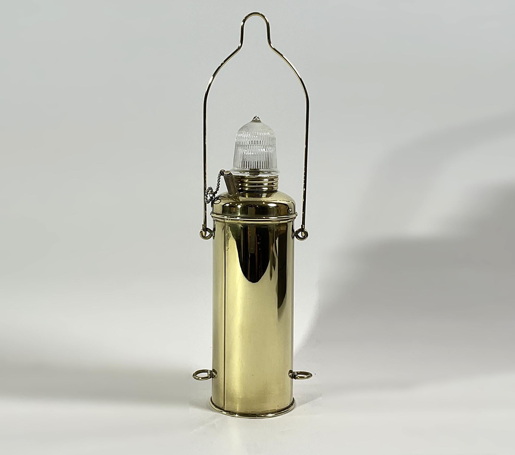 Solid brass ships anchor lantern with Fresnel glass lens. Dry cell battery lamp. Circa 1950. Fresnel glass globe. Carry handle marked with 