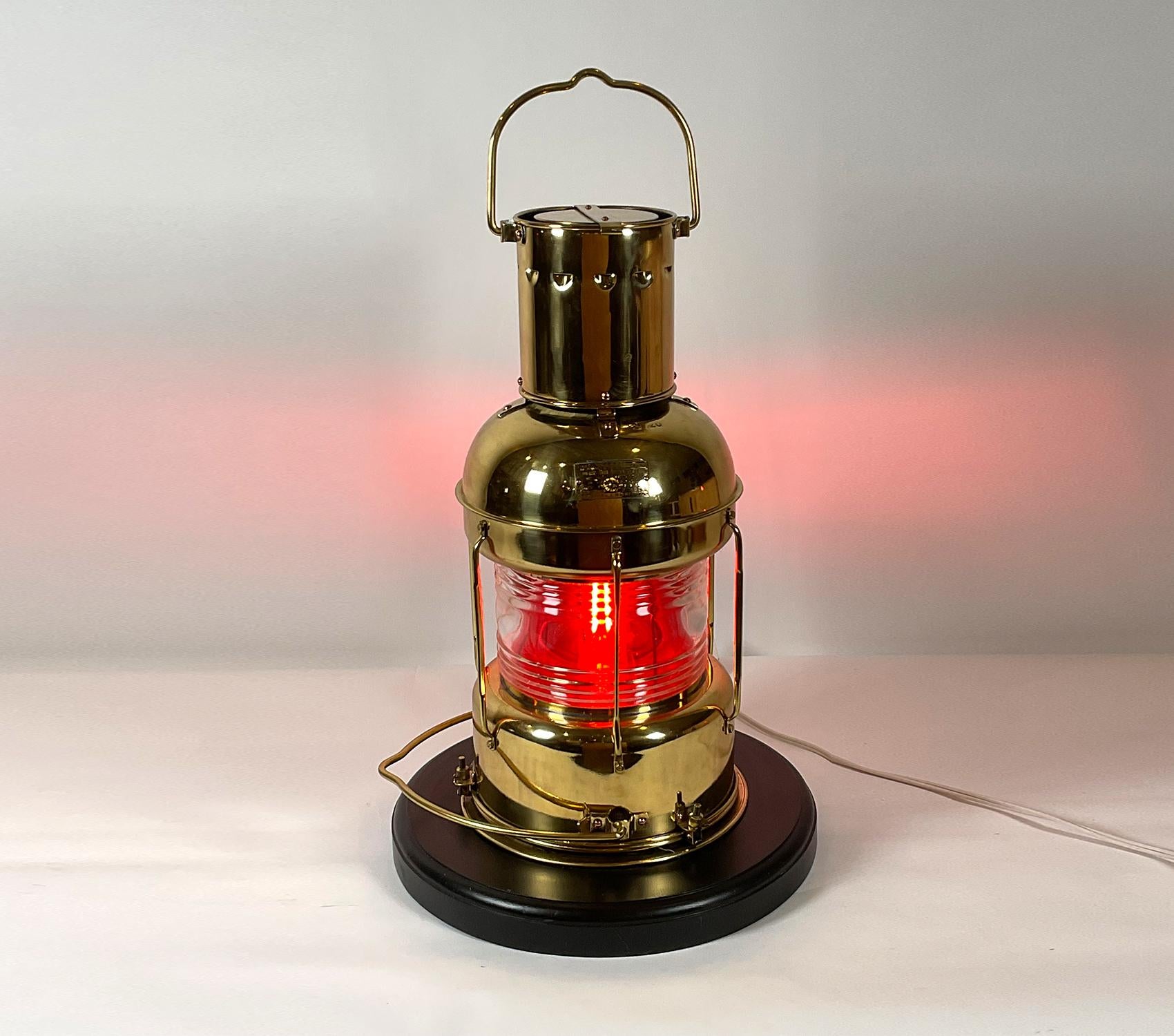 Brass ship’s lantern with clear Fresnel glass lens with removable red lens. Meticulously polished and lacquered. Mounted to a thick wood base with routed edge. Wired for electricity. Very fine condition. This would have been a back up oil lantern