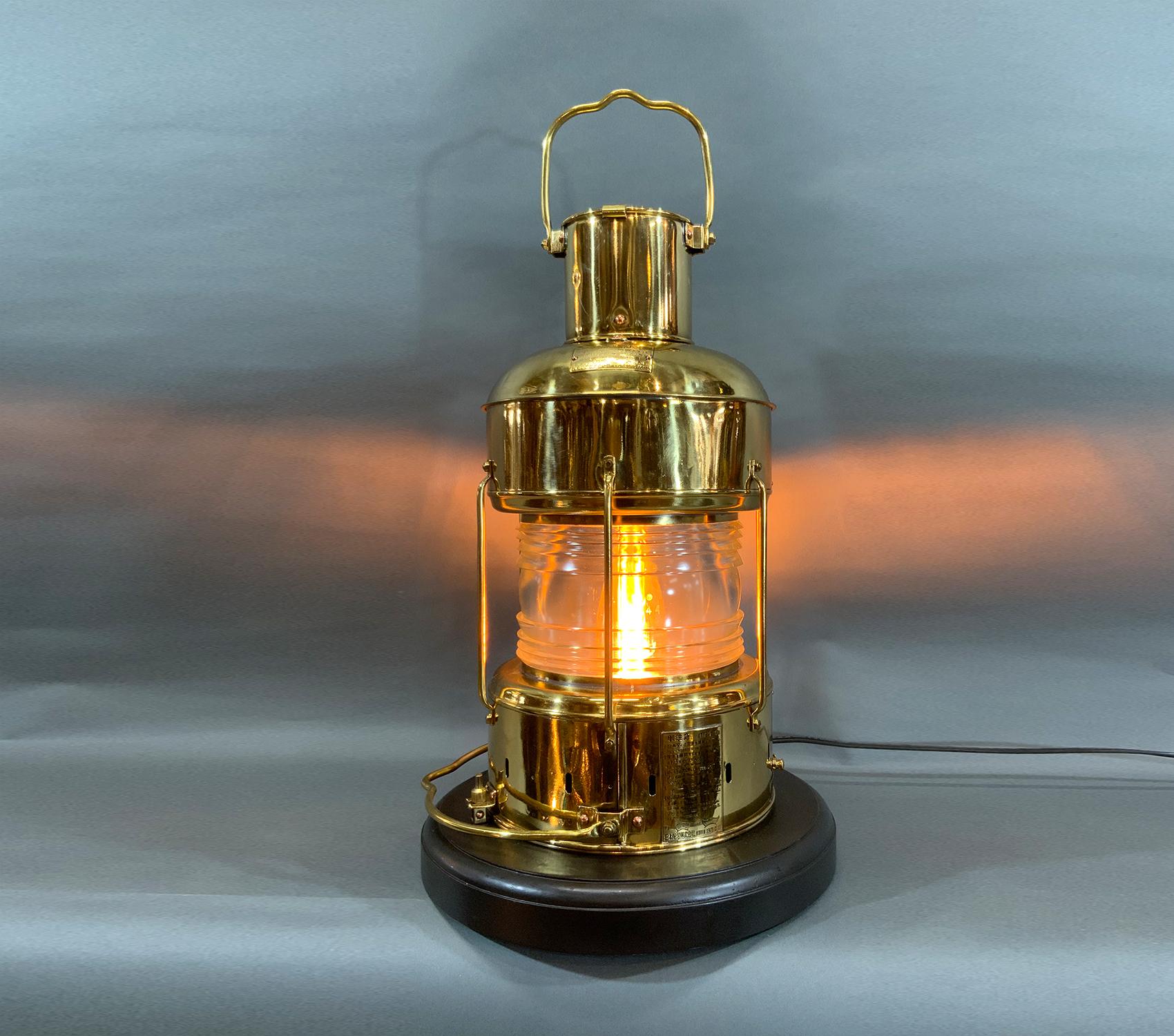 Meticulously polished and lacquered ship’s anchor lantern with Fresnel glass lens, protective bars, carry handles, etc. With Japanese maker’s tags. Circa 1970. Mounted to a thick mahogany base. Rewired for home use. 

Weight: 17 lbs
Overall