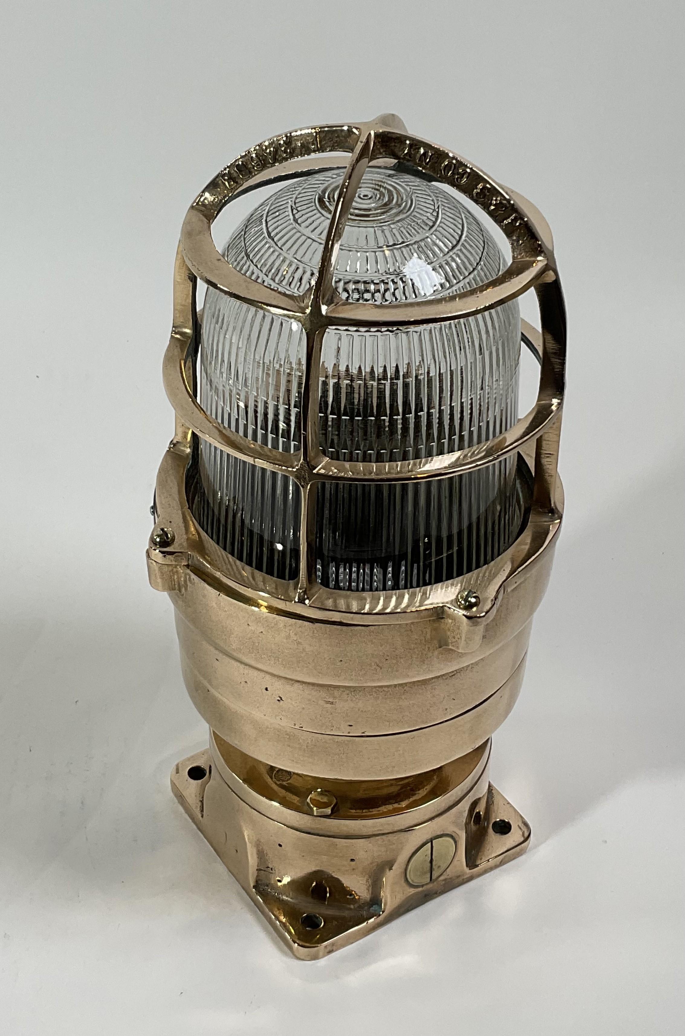 Brass marine beacon by Russel Stoll. Heavy brass ships explosion proof marine beacon. The Fresnel glass lens in protected by a heavy brass cage that is fastened to a sturdy columnar base with four flange feet. Circa 1960. 