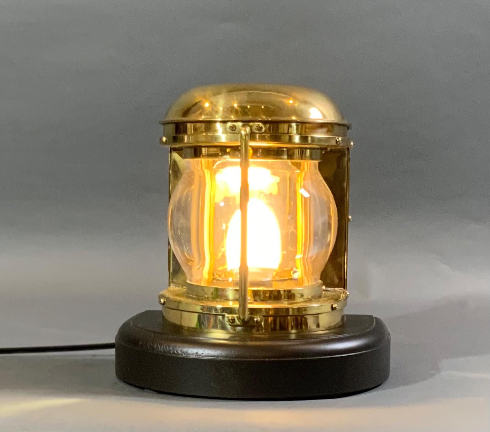 Solid brass meticulously polished and lacquered ship or boat bow lantern. Thick curved lens, protective brass header bar. Unit has been recently electrified. Mounted to a custom mahogany base. 

Weight: 7 LBS
Overall dimensions: 10” H x 10” L x