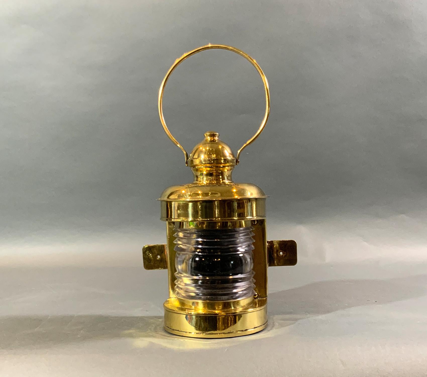 Hundert Jahre alte, hochglanzpolierte und lackierte Schiffslaterne mit Fresnel-Glaslinse, Befestigungsflanschen, Tragegriff aus Bügel, etc. Der Name des Herstellers ist Perkins Marine Lamp Corporation, Brooklyn, N.Y. Für den Heimgebrauch verkabelt.